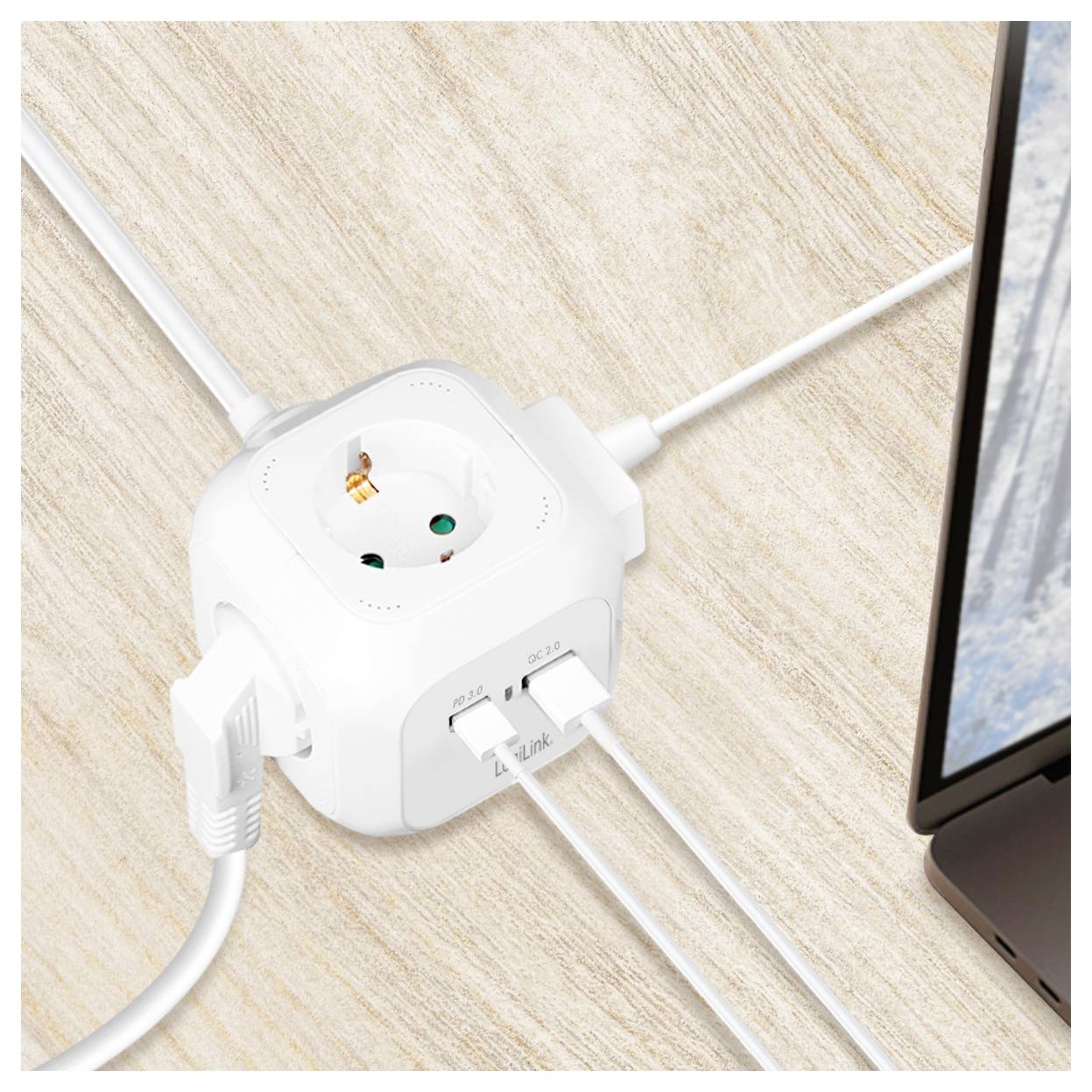 Ein weißer Verteilerstecker mit drei USB-Anschlüssen und mehreren Steckdosen liegt auf einer Holzoberfläche, rechts teilweise ein Laptop sichtbar, Kabel angeschlossen.