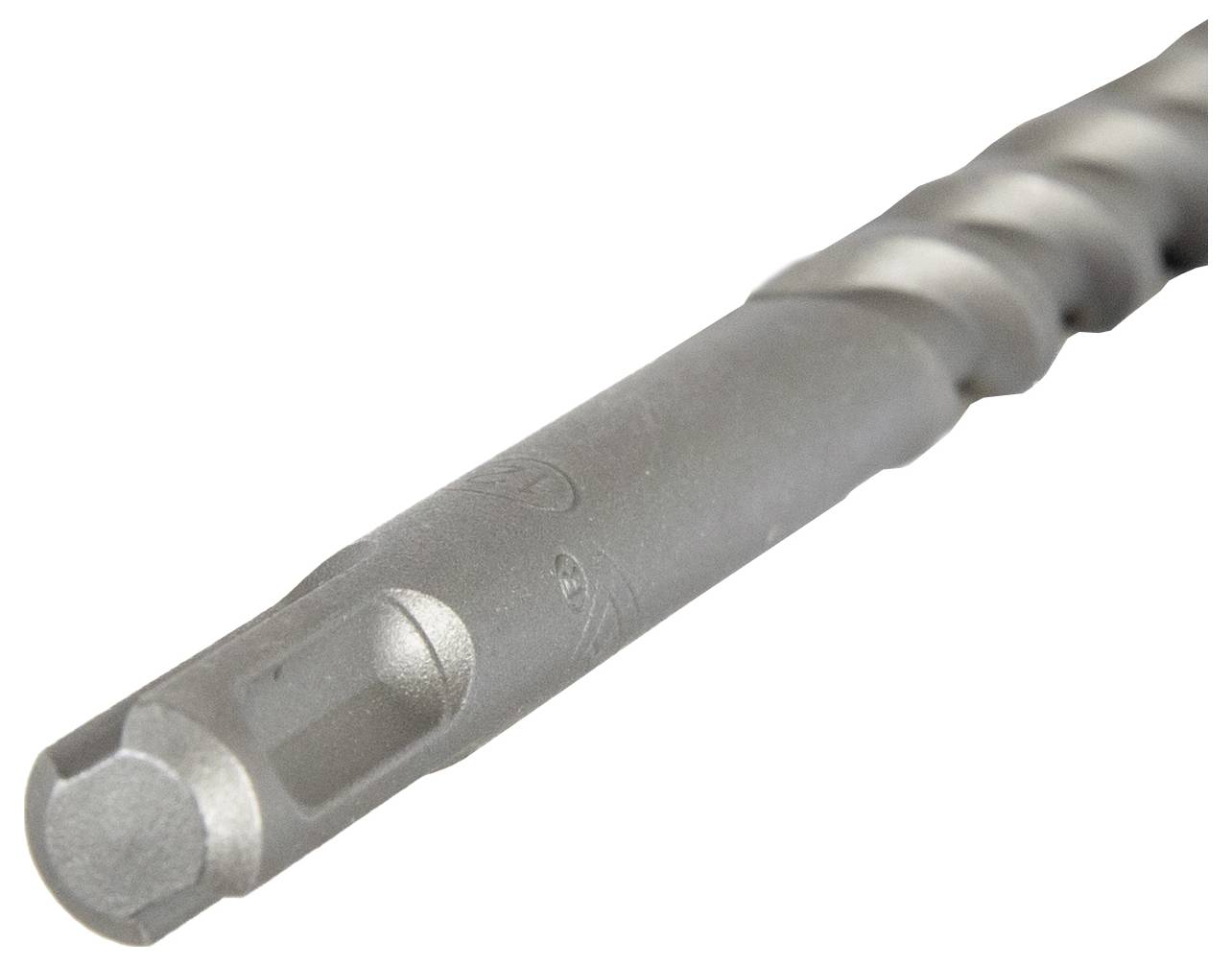 Nahaufnahme eines metallischen Bohrers, mit Fokus auf der spitzen Spitze und den Spiralrillen, verwendet zum Bohren in harte Materialien.