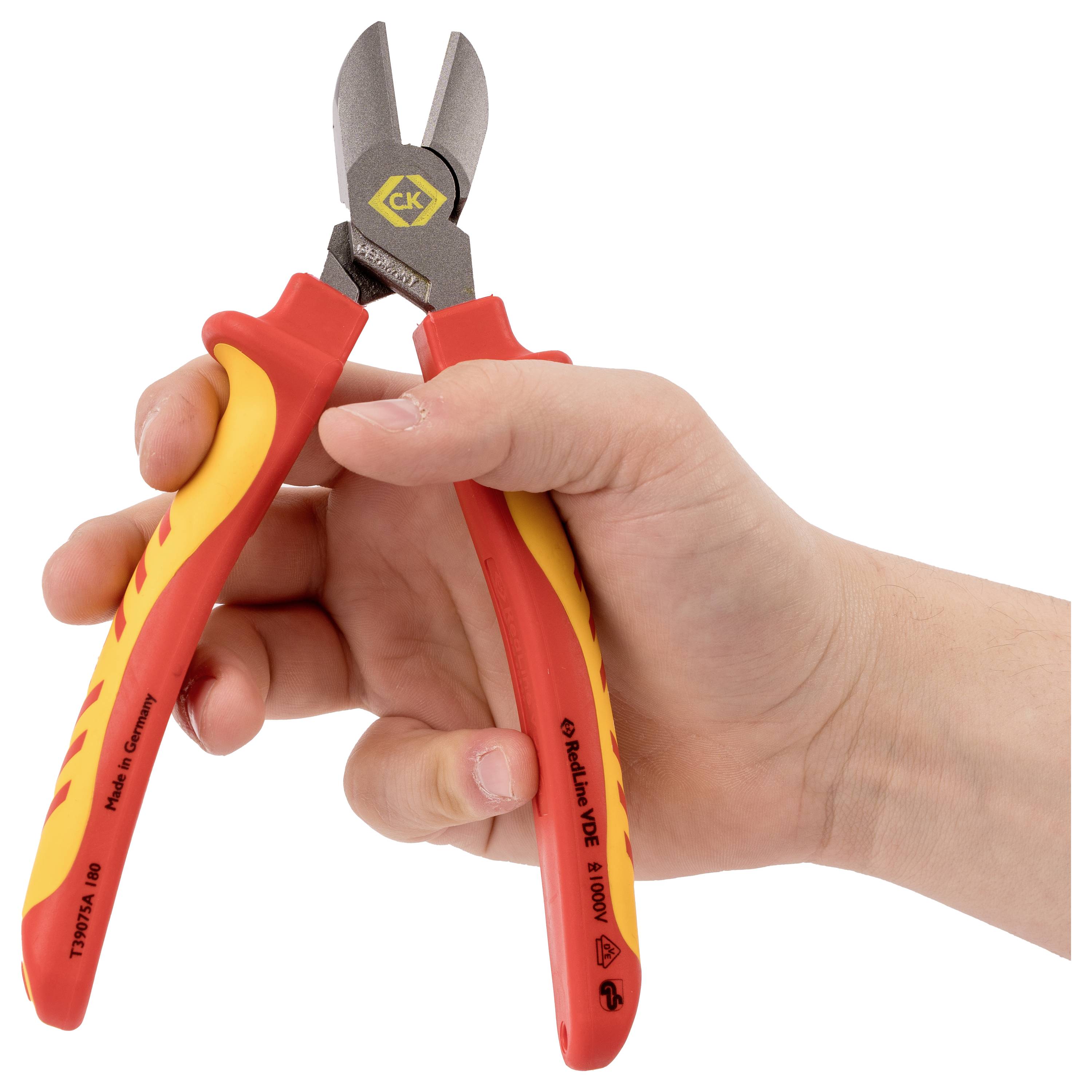 Eine Hand hält isolierte Kabelschneider mit roten und gelben Griffen und zeigt das Werkzeug bereit zur Verwendung bei elektrischen Arbeiten.