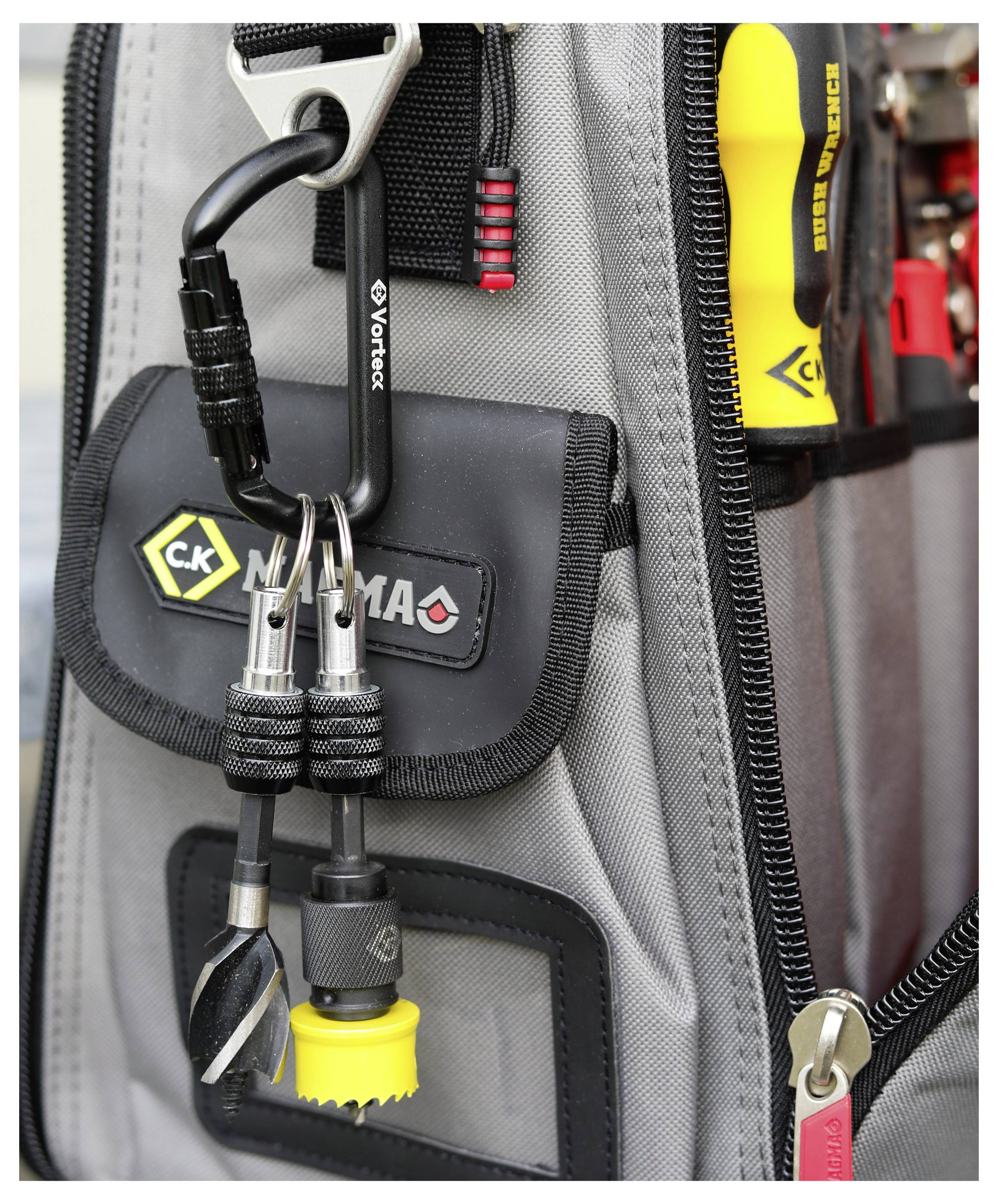 Eine Nahaufnahme einer Werkzeugtasche mit verschiedenen Werkzeugen, einschließlich Schraubenzieherbits und einem Karabiner, die an der Außentasche für einfachen Zugriff befestigt sind.