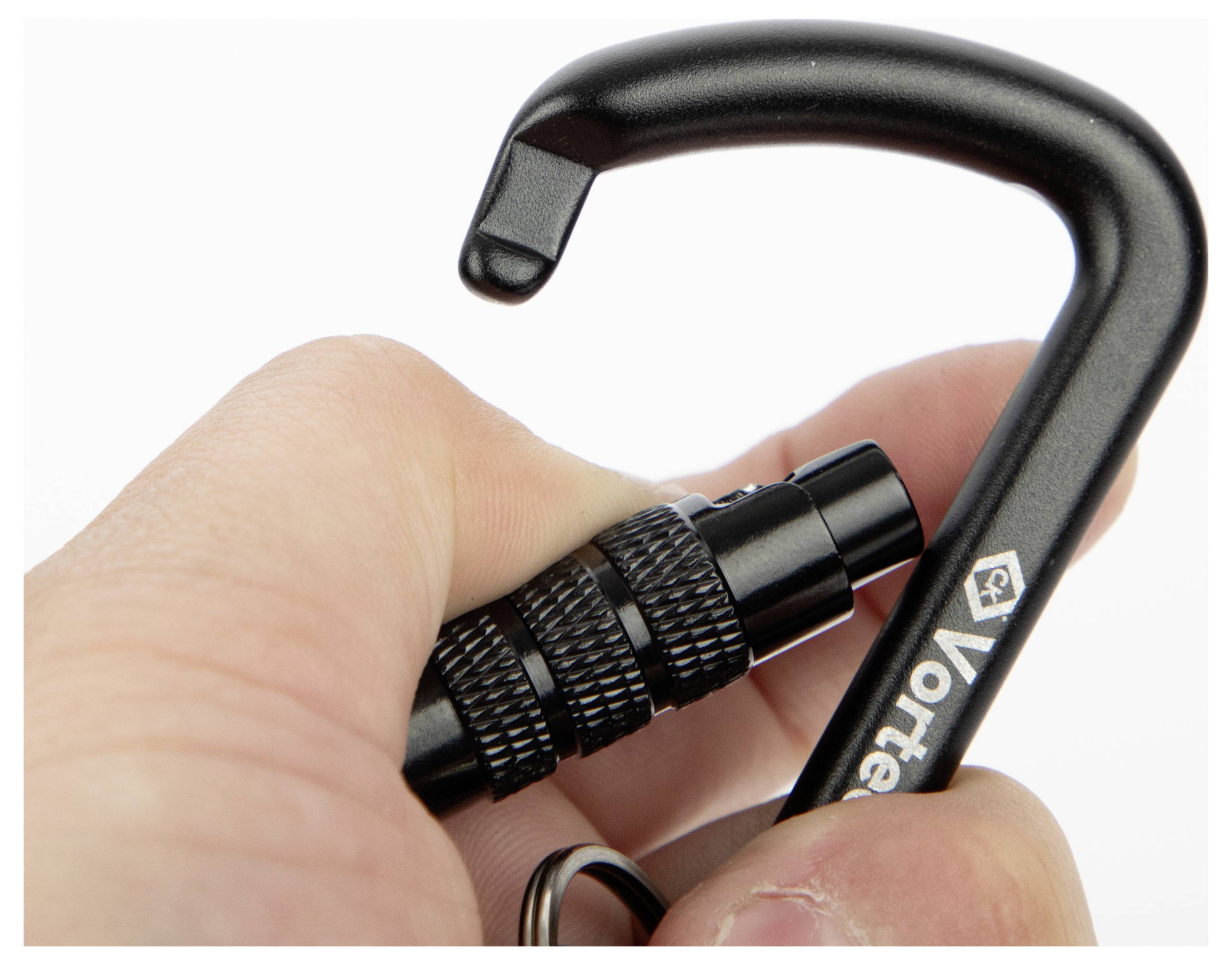 Eine Hand hält einen schwarzen Karabiner mit der Aufschrift Vortex und hebt dessen Verschlussmechanismus und strukturierte Griffoberfläche für Sicherheit und Haltbarkeit hervor.