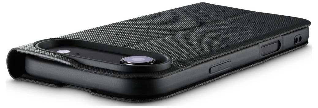 Ein schwarzes Smartphone mit einer strukturierten Hülle und sichtbarer Kameralinse, das horizontal auf einer ebenen Oberfläche liegt.