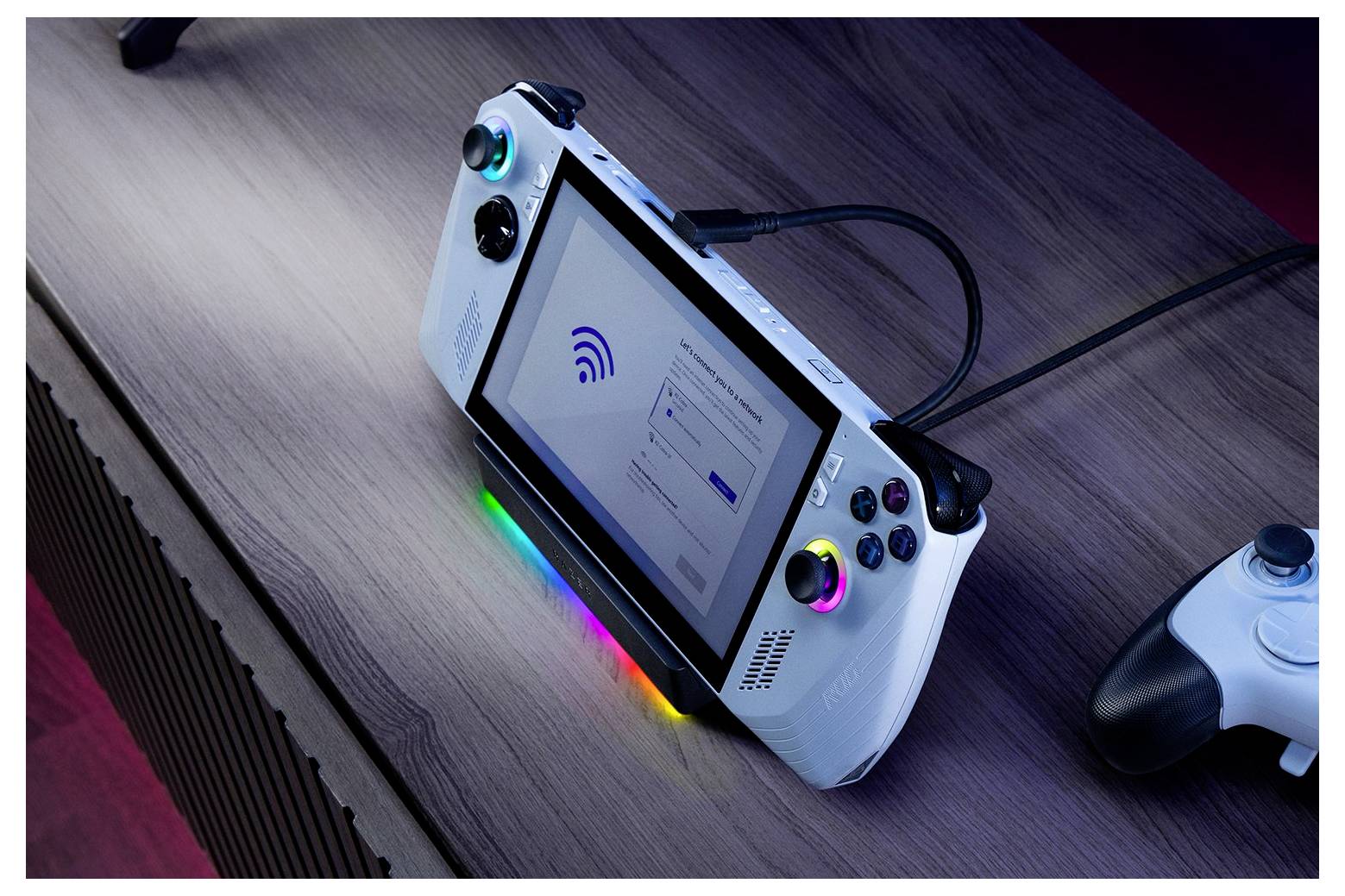 Ein tragbares Spielgerät mit einem Bildschirm, auf dem eine WLAN-Einrichtung angezeigt wird, angeschlossen an ein Ladegerät auf einem Holztisch, neben einem Spielcontroller.