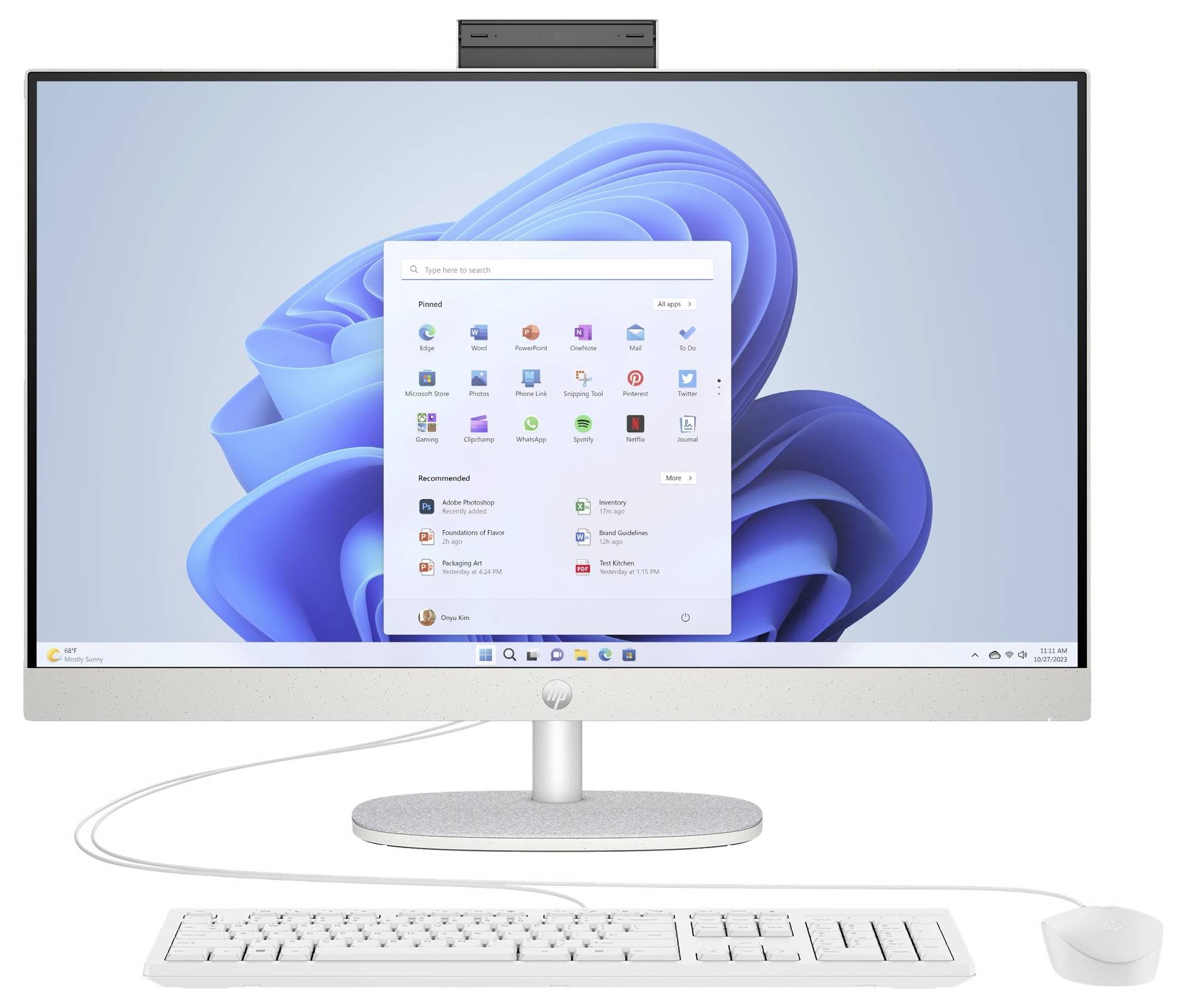 Ein Desktop-Computer mit einem großen Monitor, auf dem das Windows 11 Startmenü angezeigt wird. Eine Tastatur und eine Maus sind unterhalb des Bildschirms angeschlossen.