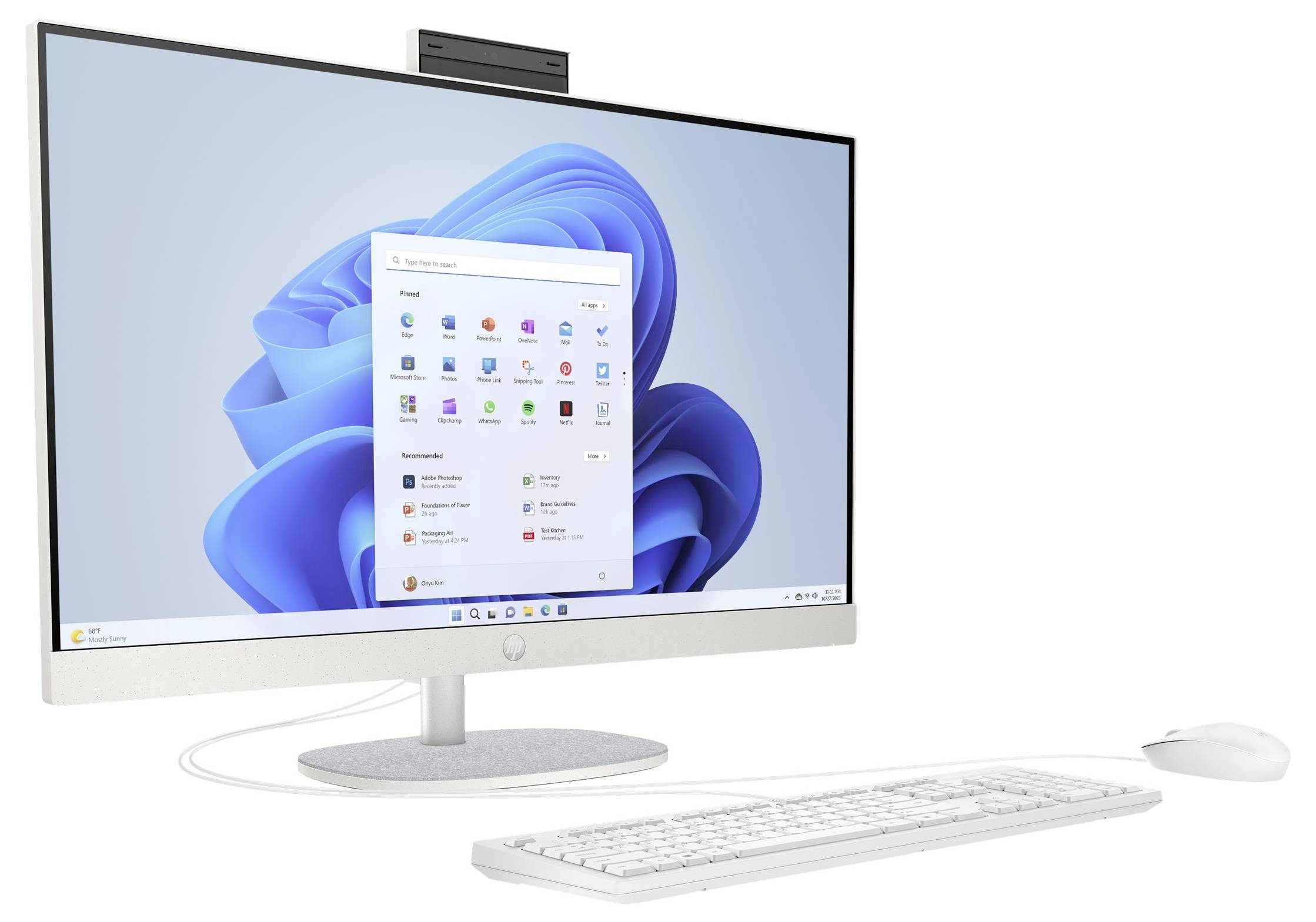 Ein moderner Desktop-Computer mit einem Breitbildmonitor, auf dem der Startbildschirm eines Windows-Betriebssystems zu sehen ist, zusammen mit einer weißen Tastatur und einer weißen Maus.