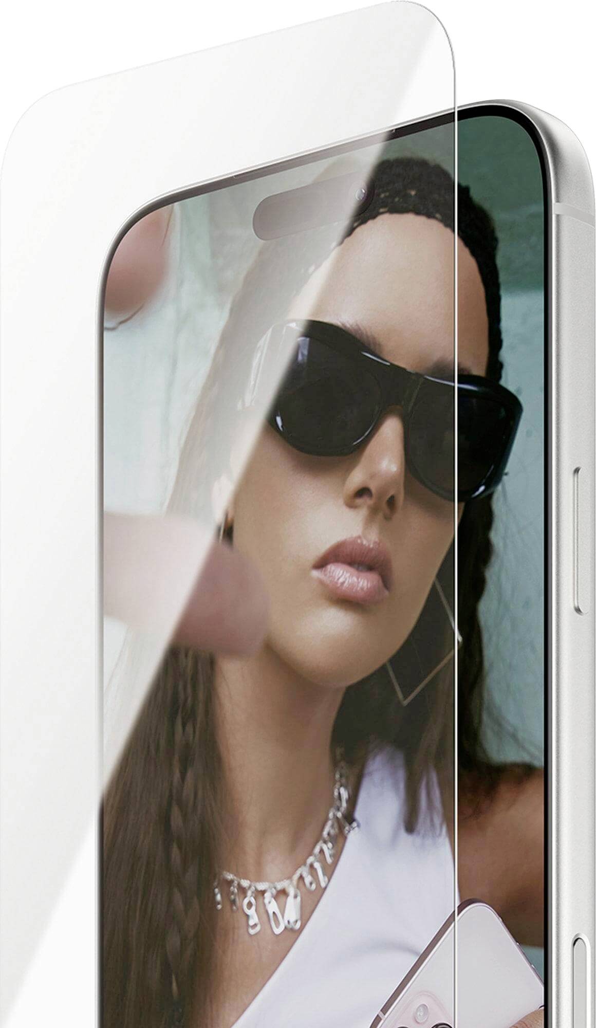 Eine Person mit Sonnenbrille spiegelt sich auf dem Bildschirm eines Smartphones mit einem teilweise aufgeklebten Displayschutz.
