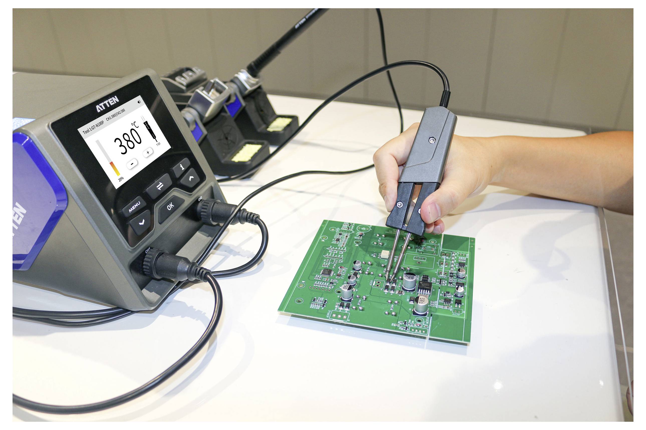 Eine Person verwendet ein Lötkolben auf einer Leiterplatte, wobei ein digitales Display '380°F' anzeigt. Elektronische Komponenten sind auf der Platine sichtbar.