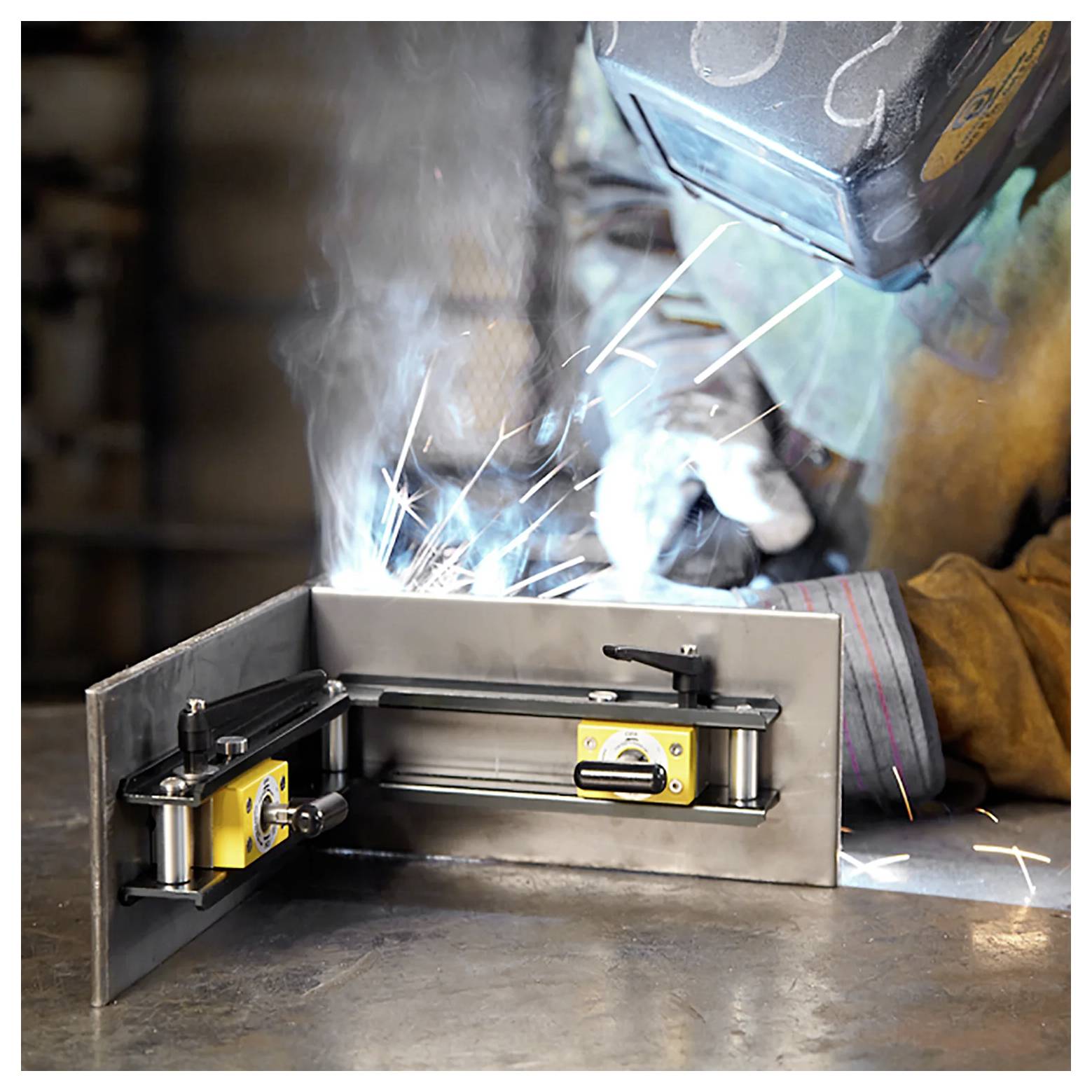 Ein Schweißer in Schutzausrüstung arbeitet an einem Metallstück mit einer Schweißmaschine und erzeugt helle Funken in einer industriellen Umgebung.