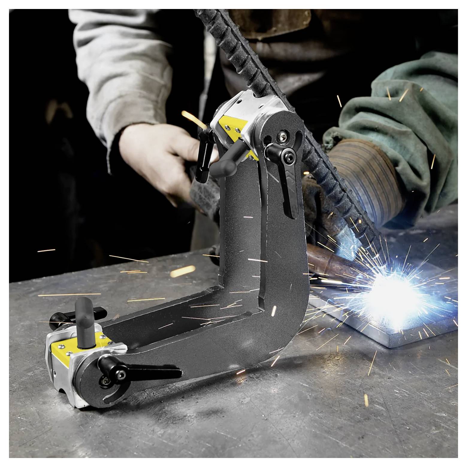 Ein Schweißer benutzt ein Schweißgerät, um Metallteile auf einer Werkbank zu verbinden, wobei sichtbare Funken entstehen und der Werker Schutzausrüstung trägt.
