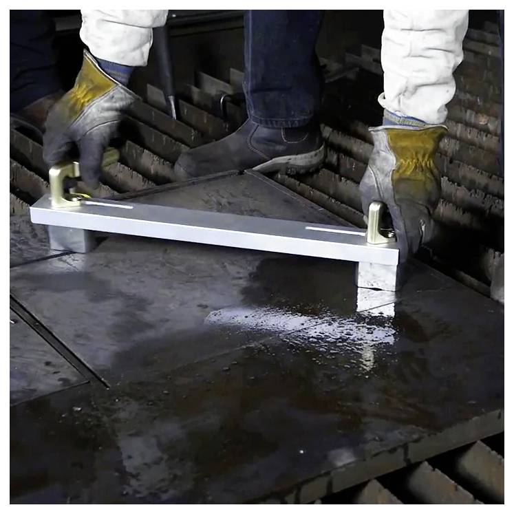 Eine Person in Handschuhen und Schutzausrüstung behandelt ein Metallstück mit Haken in einer industriellen Umgebung.