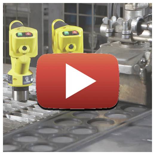 Bild eines CNC-Maschinenarbeitsbereichs mit zwei gelben magnetischen Hebern im Hintergrund. Eine Wiedergabetaste-Überlagerung deutet auf Videoinhalte hin.