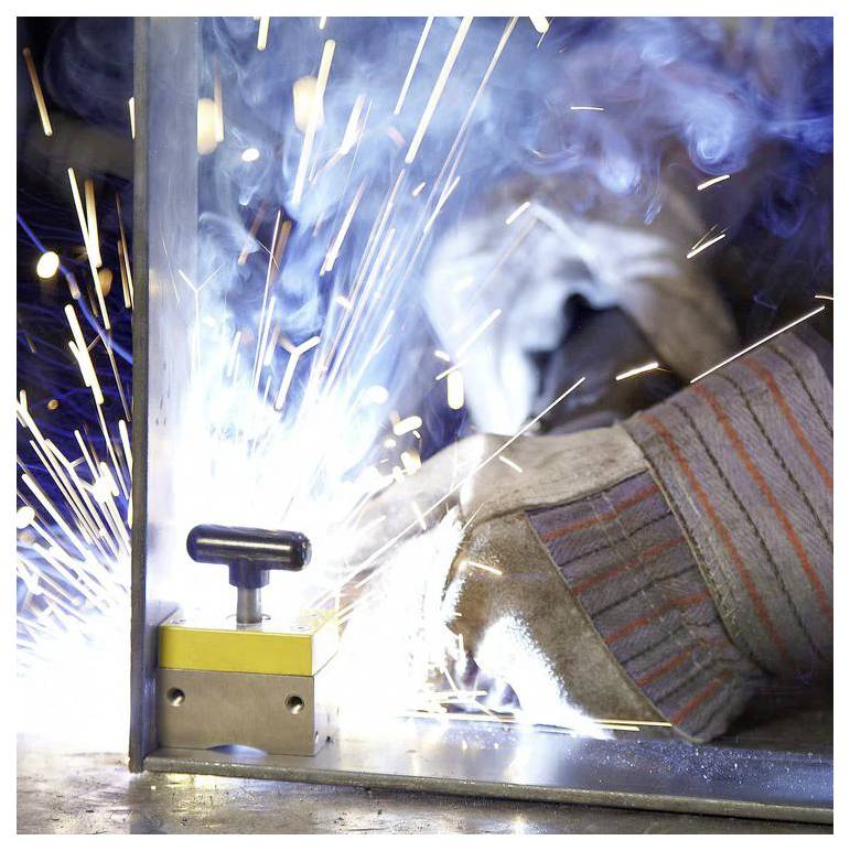 Eine Person schweißt Metall mit intensiven Funken und hellem Licht und trägt dabei Schutzhandschuhe. Die Szene unterstreicht industrielle Arbeit und Sicherheit.