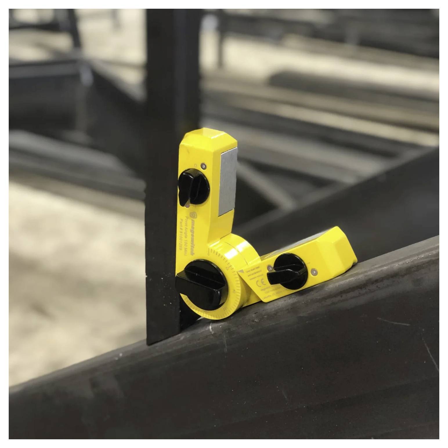 Ein gelber magnetischer Winkelfinder ist an einem Stahlträger befestigt und zeigt eine Winkelmessung für präzise Metallbearbeitung.