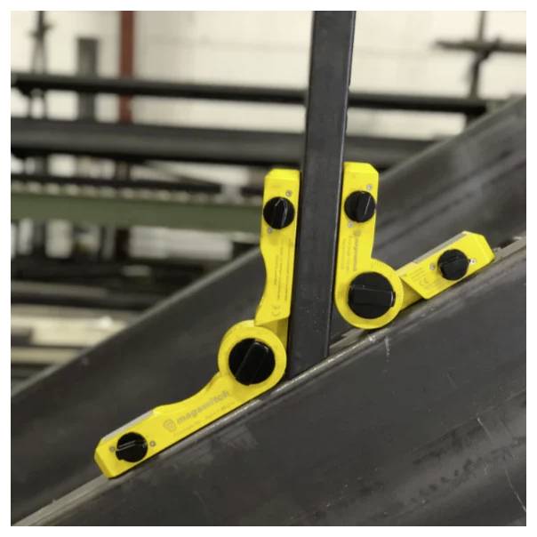 Ein gelber magnetischer Winkelfinder, der den Winkel zwischen zwei sich kreuzenden Metallträgern in einer industriellen Umgebung misst.
