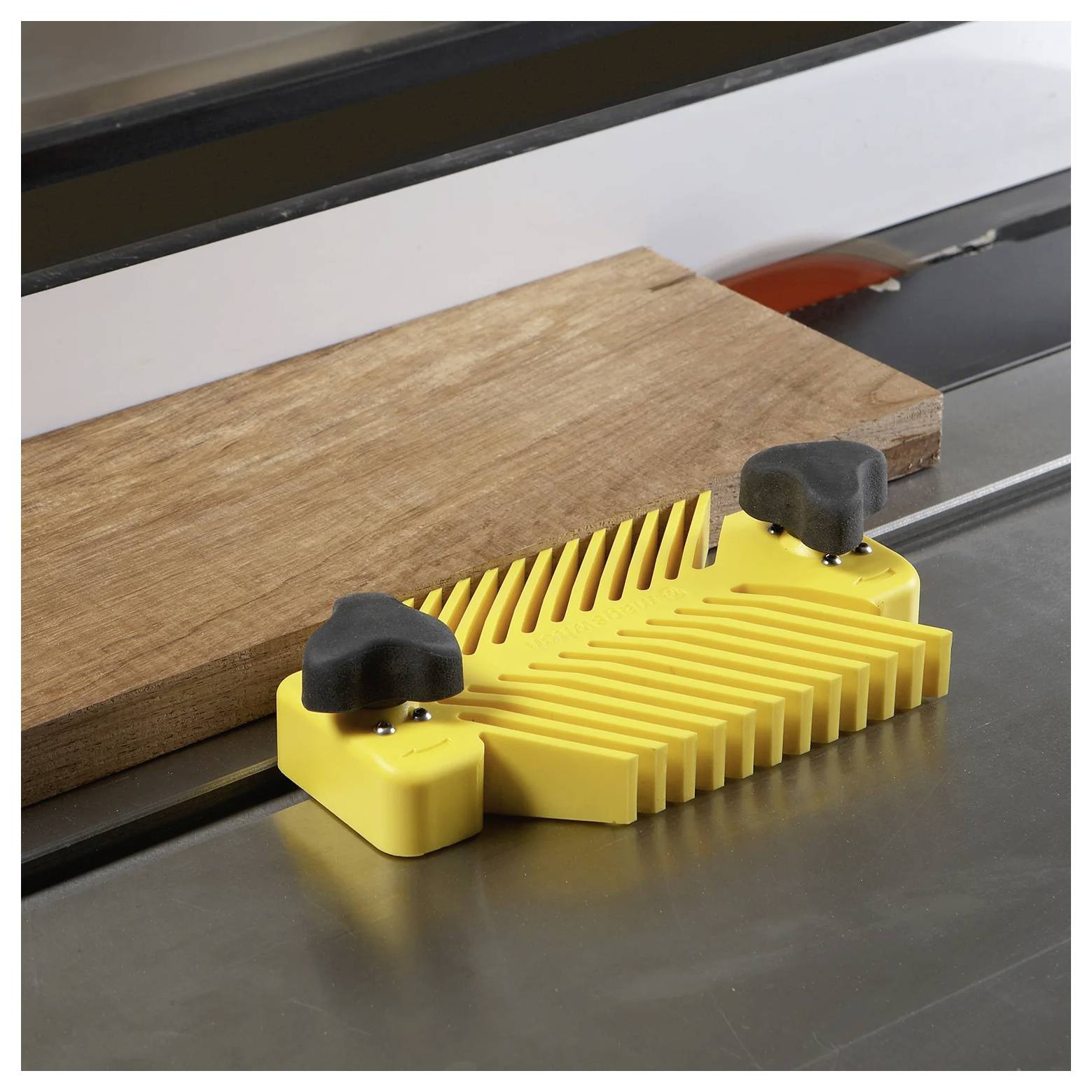 Eine Kreissäge führt ein Holzstück mittels eines gelben Federbügels, um gerade, kontrollierte Schnitte zu gewährleisten. Sicherheitsausrüstung wird vorausgesetzt.