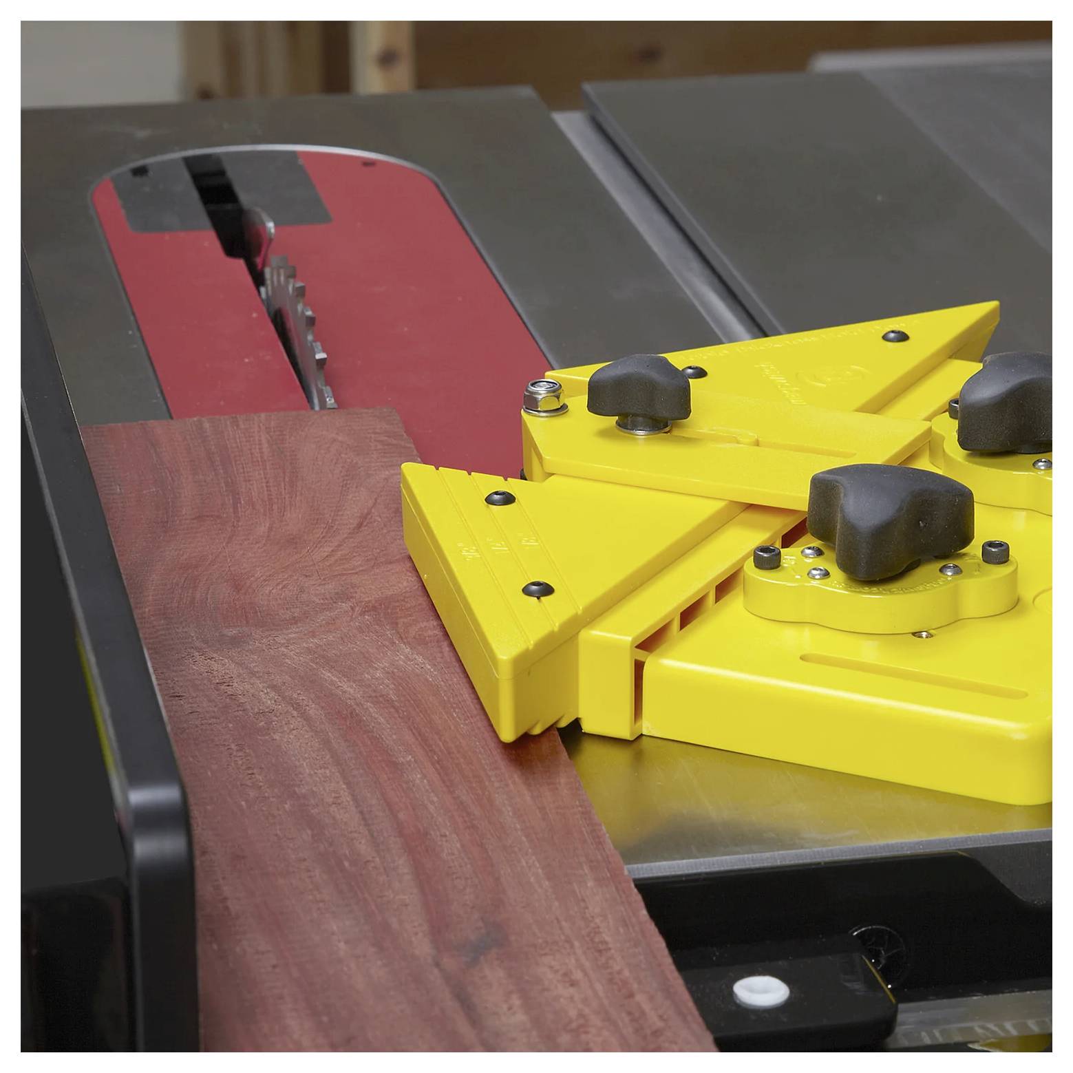 Eine Kreissäge mit einem gelben Schiebeholz führt ein Holzstück zur Klinge und gewährleistet Präzision und Sicherheit beim Schneiden.
