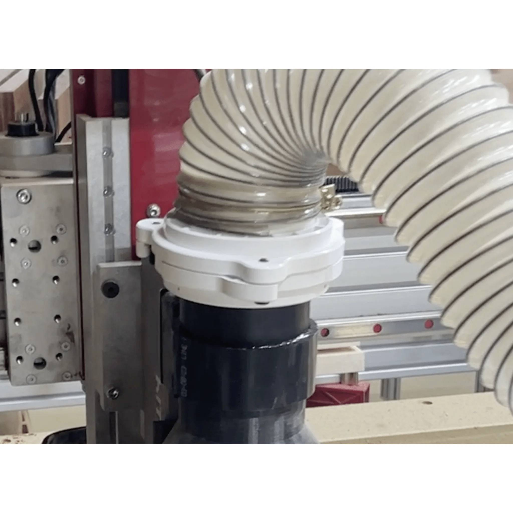 Eine CNC-Maschine mit einem in Betrieb befindlichen Staubabsaugsystem, bei dem ein flexibler Schlauch am Spindelbereich angeschlossen ist, um Staubansammlungen zu verhindern.