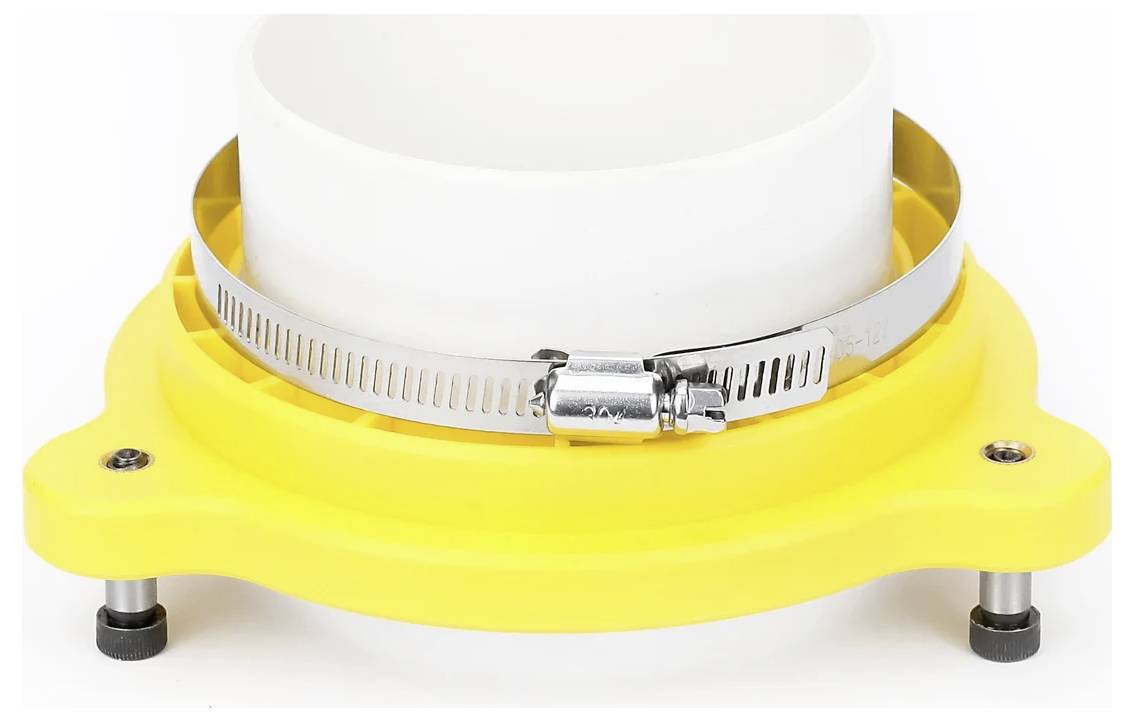 Eine gelbe Plastikstruktur mit einer Metallklemme sichert ein weißes zylindrisches Objekt.