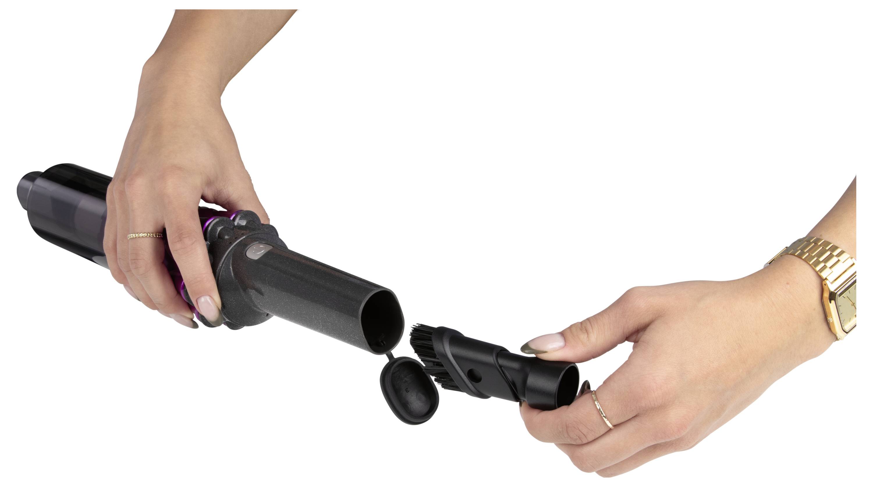 Eine Person montiert ein schwarzes tragbares Gerät und verbindet dabei zwei zylindrische Teile. Die Szene konzentriert sich auf die Hände und das Gerät.