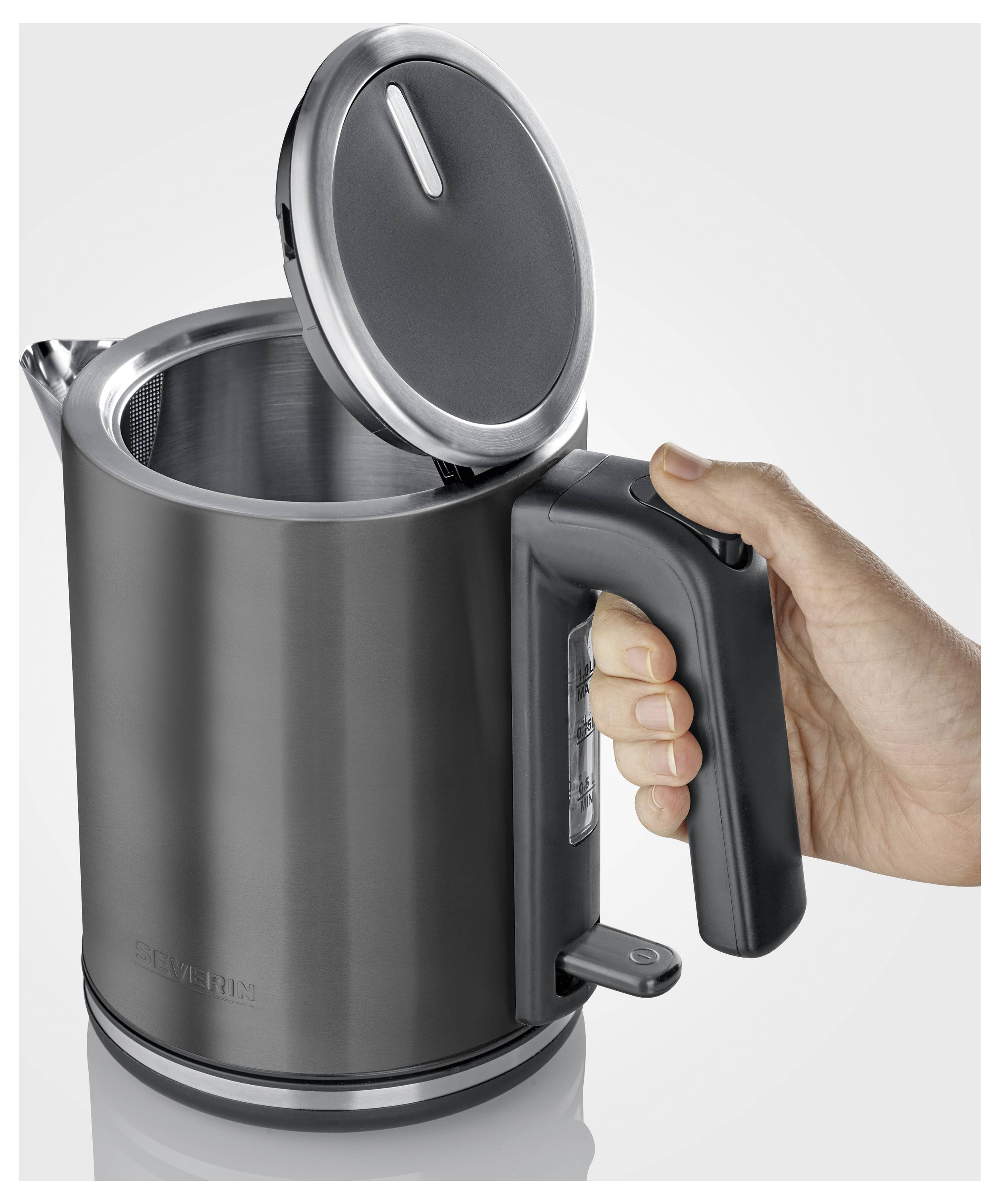 Eine Person hält einen grauen elektrischen Wasserkocher mit geöffnetem Deckel, der das Innere zeigt. Der Wasserkocher verfügt über einen Griff und einen Knopf in der Nähe der Basis.