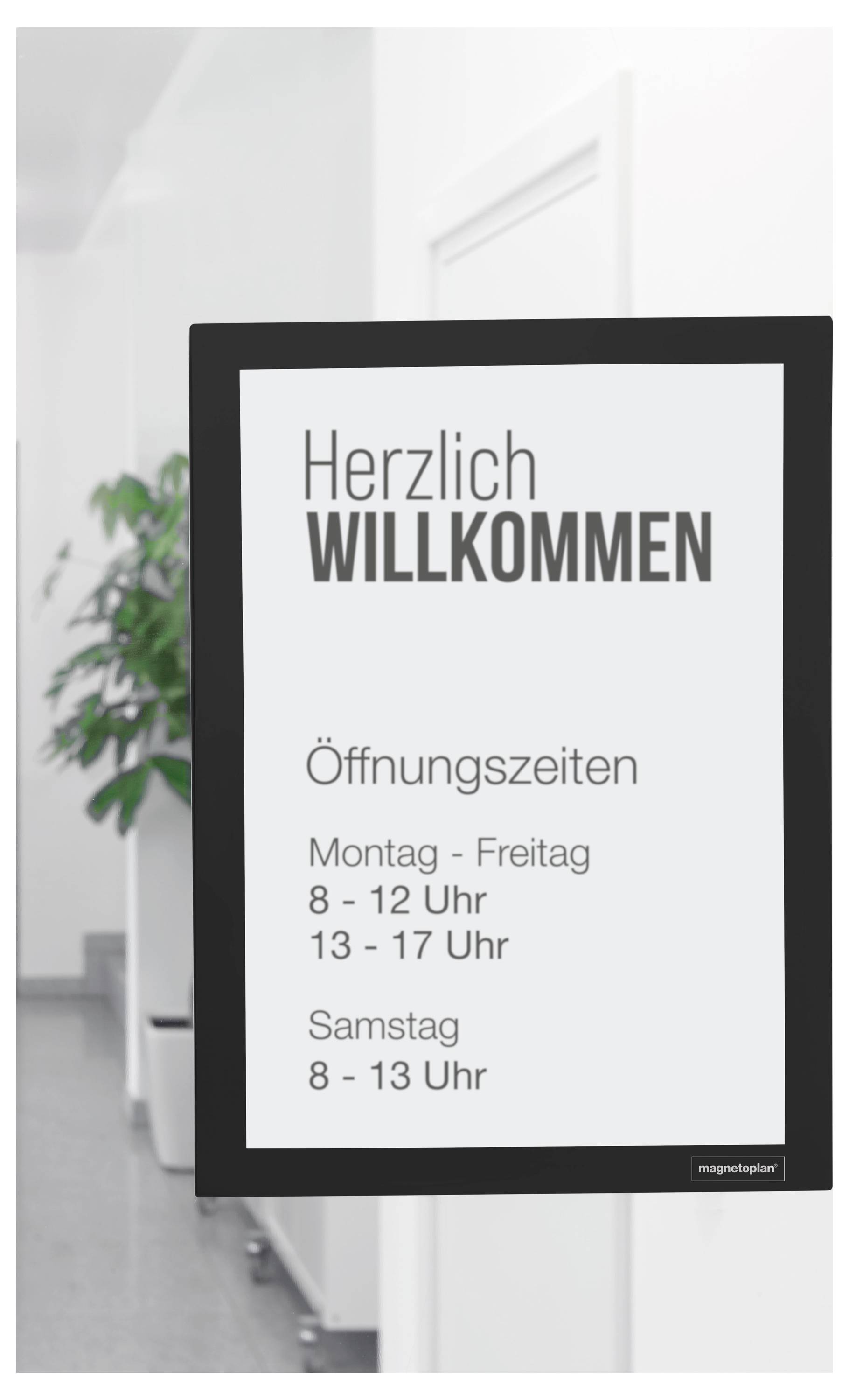 Herzlich Willkommen<br><br>Öffnungszeiten:<br>Montag-Freitag 8-12, 13-17 Uhr<br>Samstag 8-13 Uhr<br><br>[Schild befindet sich in einem Flur mit einer Zimmerpflanze]