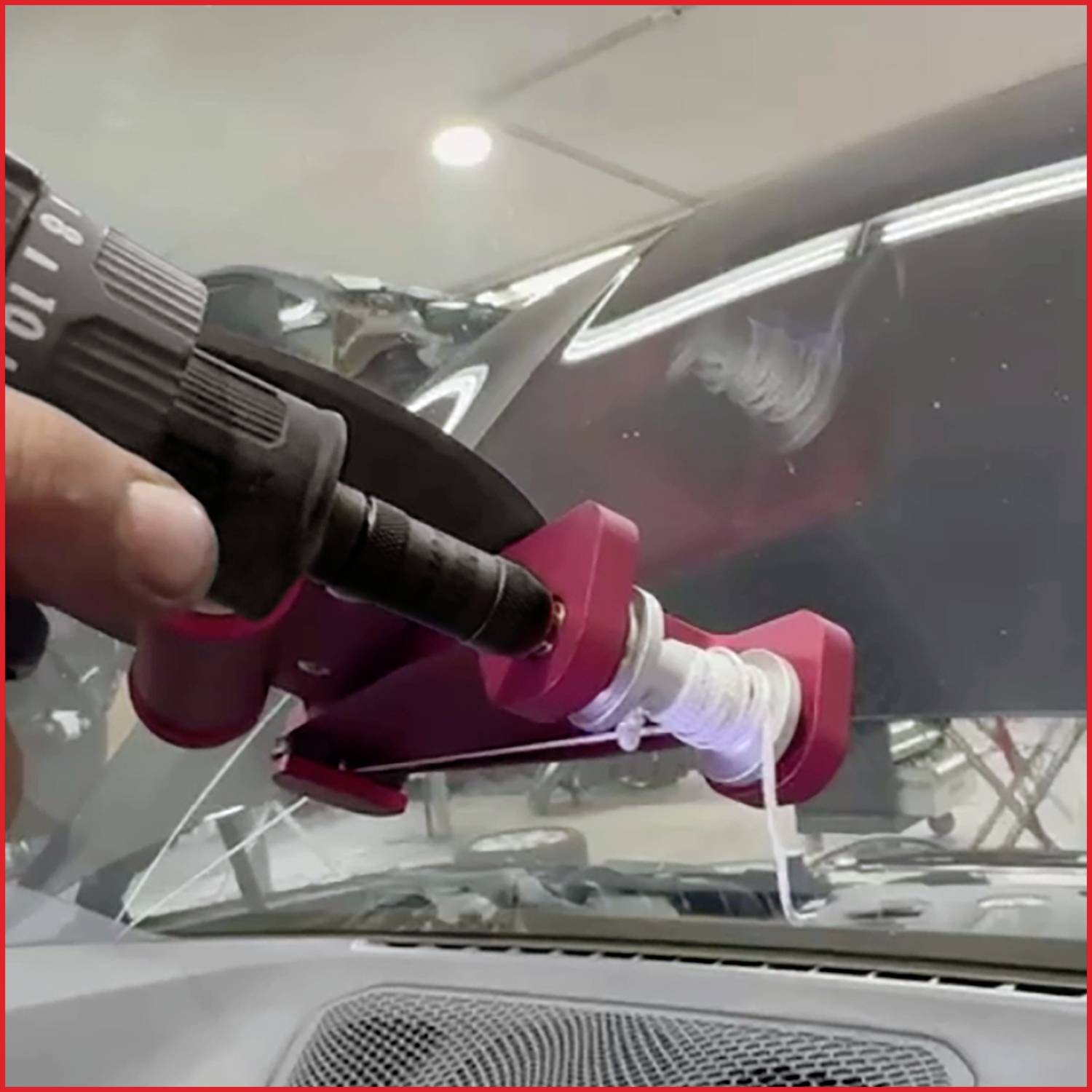 Eine Hand benutzt ein Werkzeug, um einen Riss in der Windschutzscheibe eines Autos zu reparieren und zeigt einen laufenden Reparaturprozess im Innenraum.