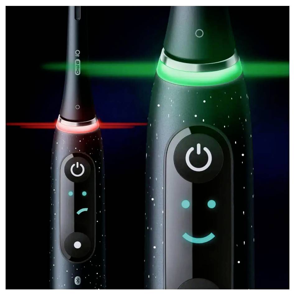 Elektrische Zahnbürste mit einer digitalen Anzeige, die ein lächelndes Gesicht in Grün zeigt, was die korrekte Anwendung signalisiert; rotes Licht deutet auf falsches Zähneputzen hin.