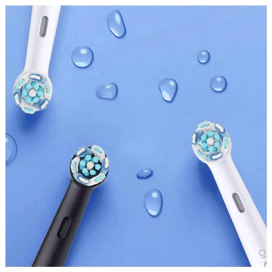 Elektrische Zahnbürstenköpfe mit blauen Borsten und Wassertropfen auf einem hellblauen Hintergrund.