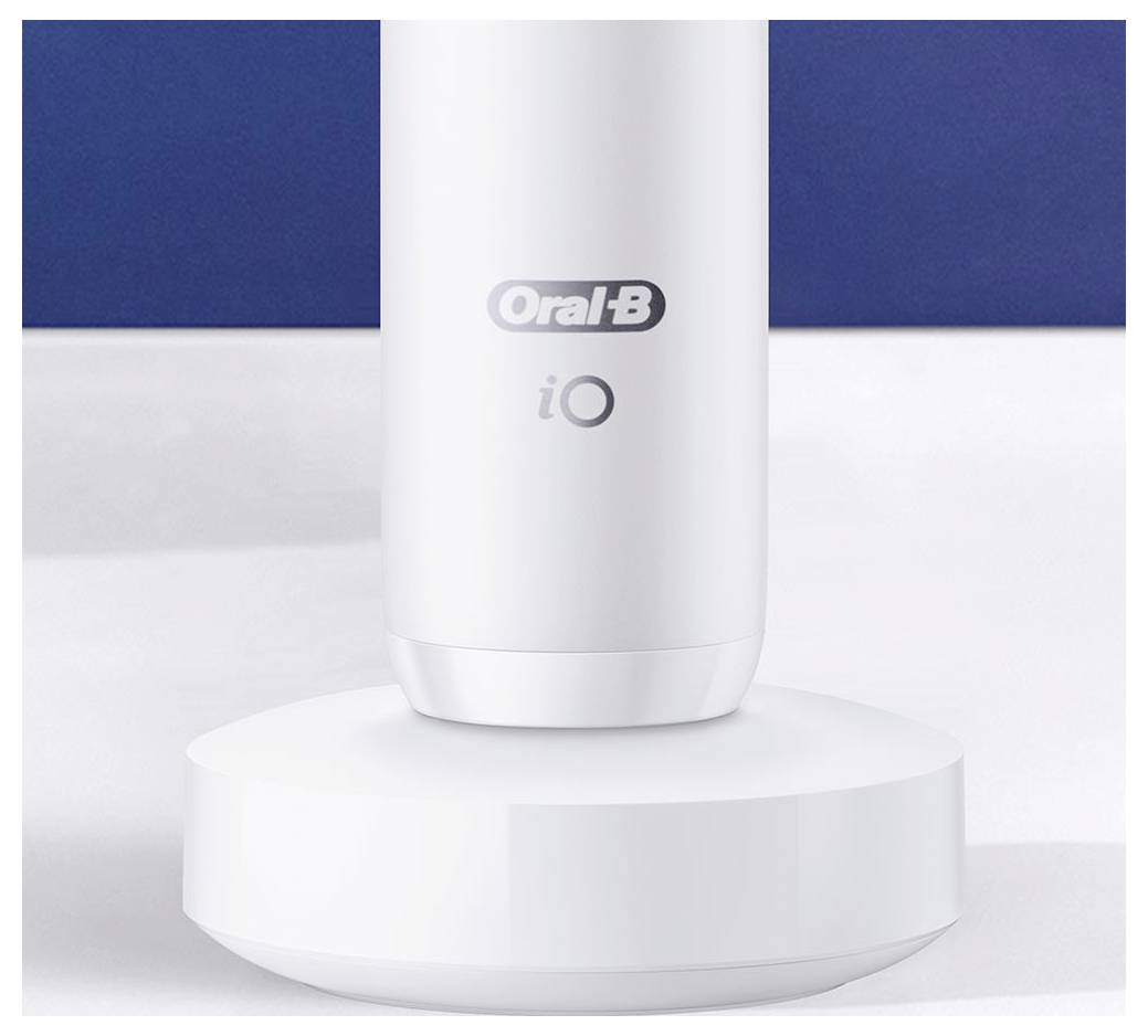 Eine weiße elektrische Zahnbürsten-Basis mit dem 'Oral-B iO' Logo, auf einer weißen Oberfläche vor blauem Hintergrund.