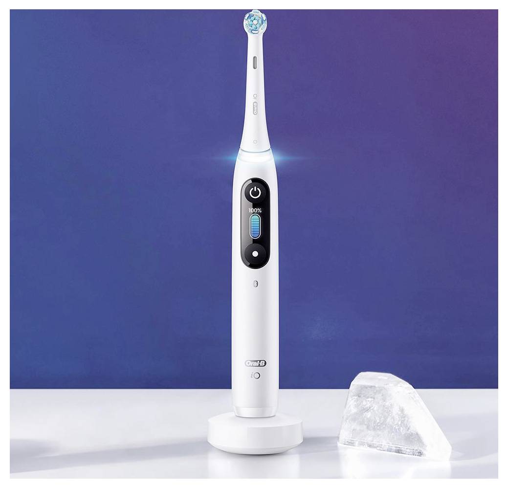 Eine weiße elektrische Zahnbürste auf ihrer Ladestation vor einem blauen Hintergrund, mit einem kleinen Eiswürfel in der Nähe, der Frische betont.