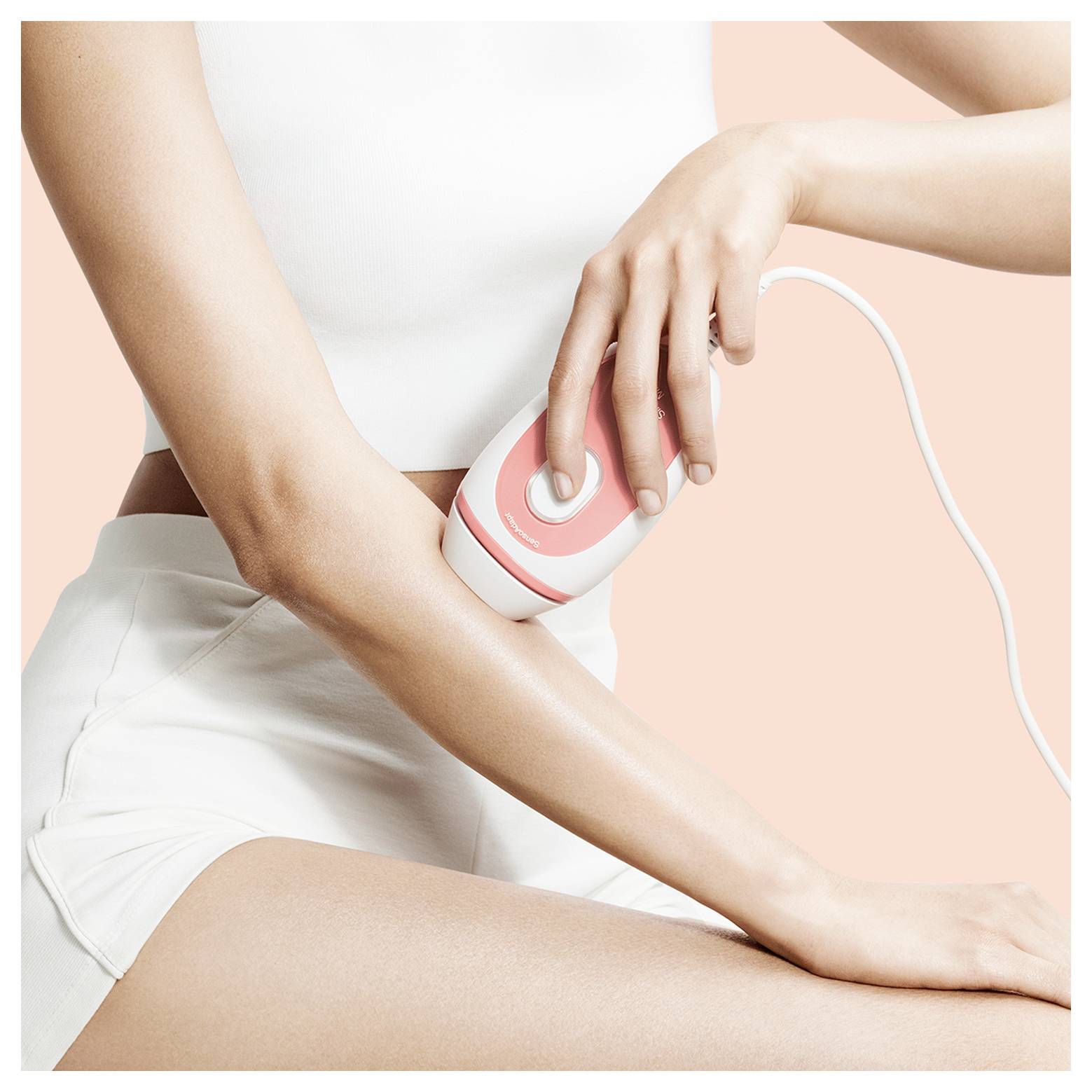 Eine Person verwendet ein tragbares Gerät auf ihrem Unterarm für eine Hautpflege- oder Beautybehandlung und veranschaulicht eine benutzerfreundliche Heimtechnologie.