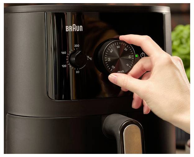 Eine Hand stellt den Temperaturregler an einem Braun-Gerät ein, der Einstellungen von 80 bis 200 Grad Celsius zeigt.