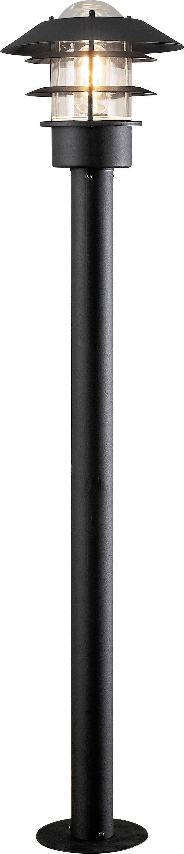 Eine hohe, schwarze Außenlaterne mit einer transparenten zylindrischen Lichtarmatur und einer abgedeckten Spitze, die von einer warmen Glühbirne beleuchtet wird.