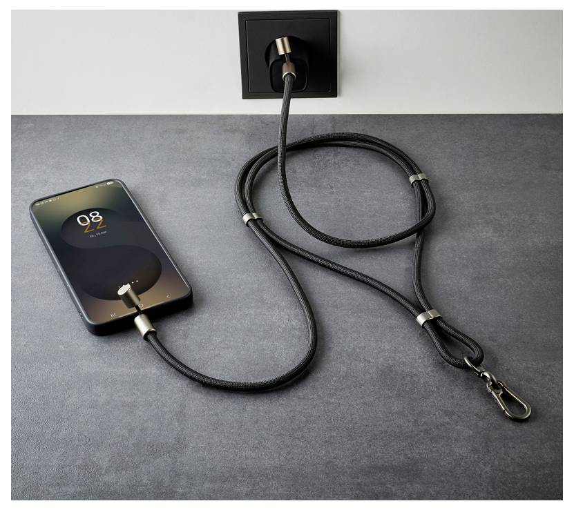 Ein Smartphone, das '8:22' anzeigt, lädt auf einer grauen Oberfläche mit einem schwarzen Kabel, das an eine Steckdose angeschlossen ist.