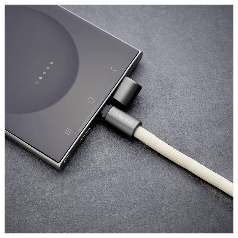 Ein Smartphone, das mit einem beigen Ladekabel auf einer dunklen Oberfläche verbunden ist. Der Bildschirm des Telefons zeigt ein teilweise aufgeladenes Batteriesymbol.