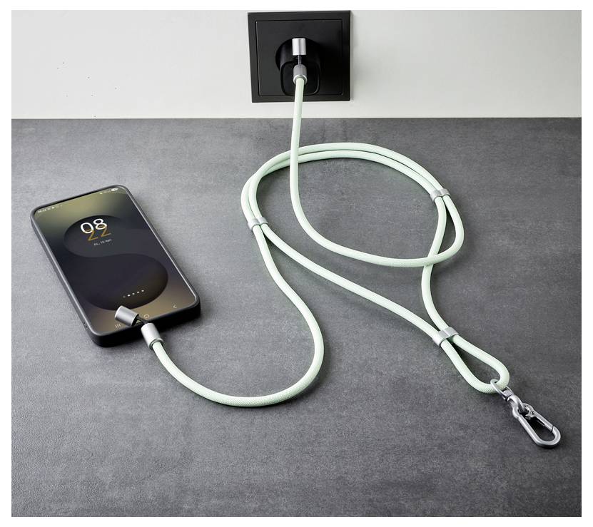 Ein Smartphone ist über ein langes, grünes Ladekabel mit einem Karabiner an einer Wandsteckdose angeschlossen. Das Telefon zeigt '02:22 PM'.