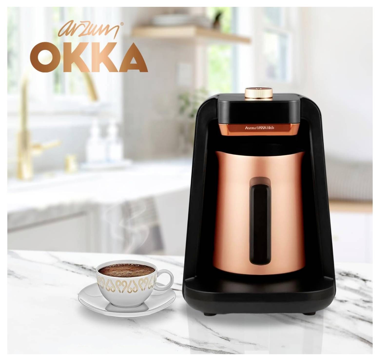 Kupferfarbener Kaffeemaschine auf einer Marmorarbeitsplatte mit einer Tasse Kaffee davor. Küchenkulisse mit unscharfem Waschbecken und Dekoration. Markenlogo 'Arzum OKKA'.