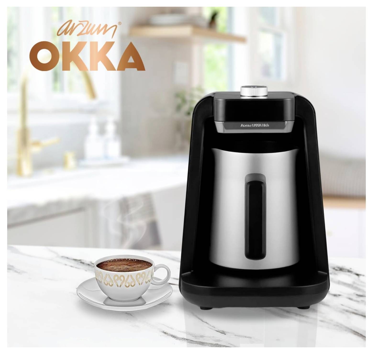 Ein Kaffeemaschine mit einer Chromkanne neben einer Tasse türkischem Kaffee auf einer Marmorarbeitsplatte. 'Arzum OKKA' Logo in der oberen linken Ecke.