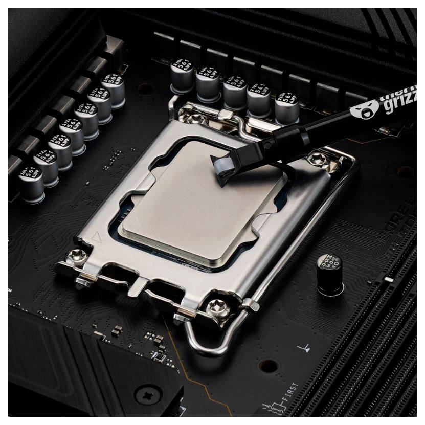 Eine CPU mit einem Werkzeug zur Aufbringung von Wärmeleitpaste ist auf einer Motherboard zu sehen, was den Prozess des Auftragens von Wärmeleitpaste zur Verbesserung der Wärmeableitung verdeutlicht.