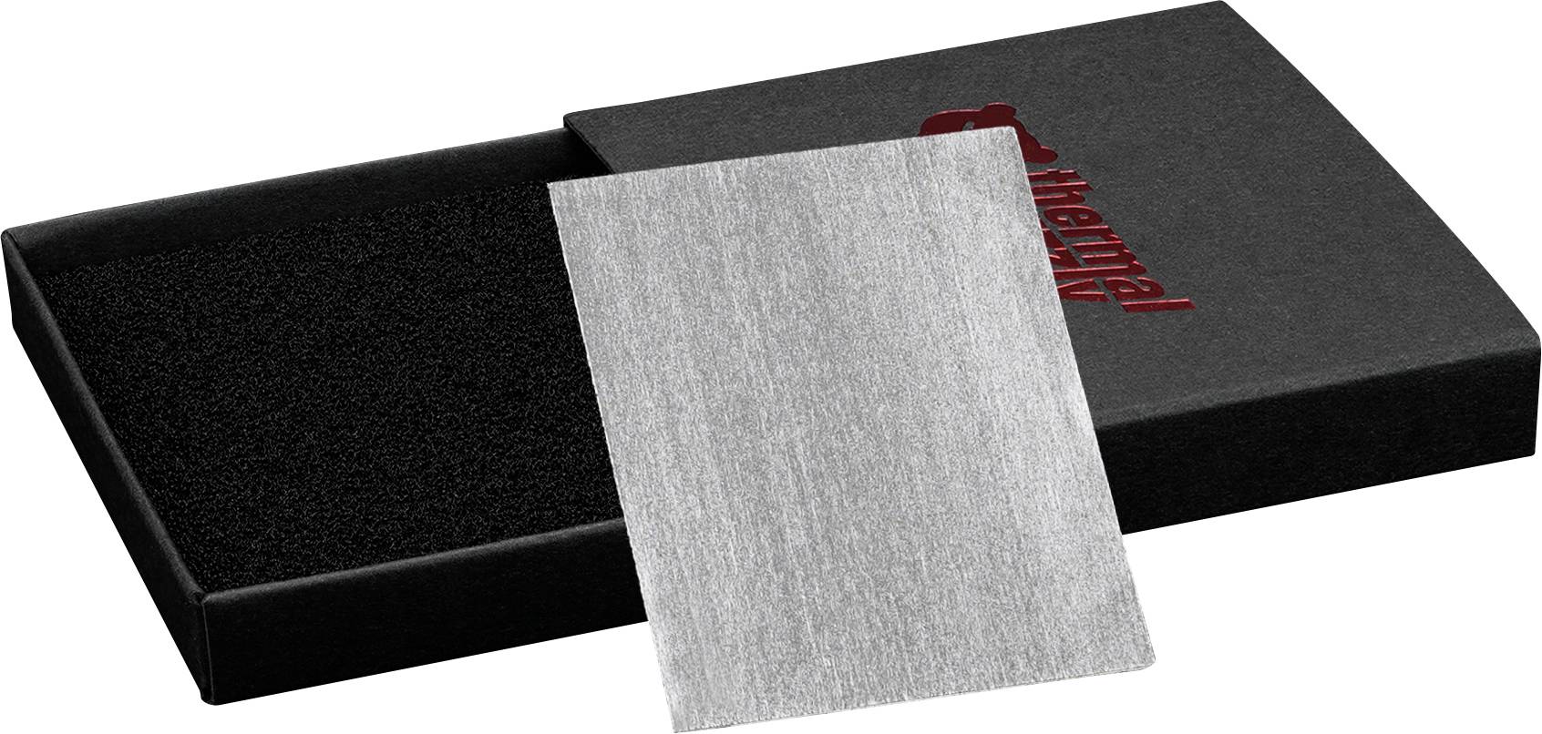Ein silberfarbener Wärmeleitpad, der auf einem schwarzen Schaumstoffkissen in einer offenen schwarzen Box liegt, auf deren Deckel teilweise das Wort 