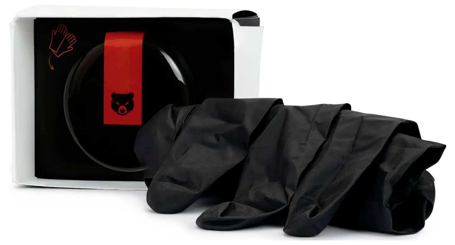 Eine Schachtel schwarzer Einweghandschuhe mit einem Bären-Logo auf der Vorderseite. Eine Illustration auf der Schachtel zeigt, wie man die Handschuhe anzieht.