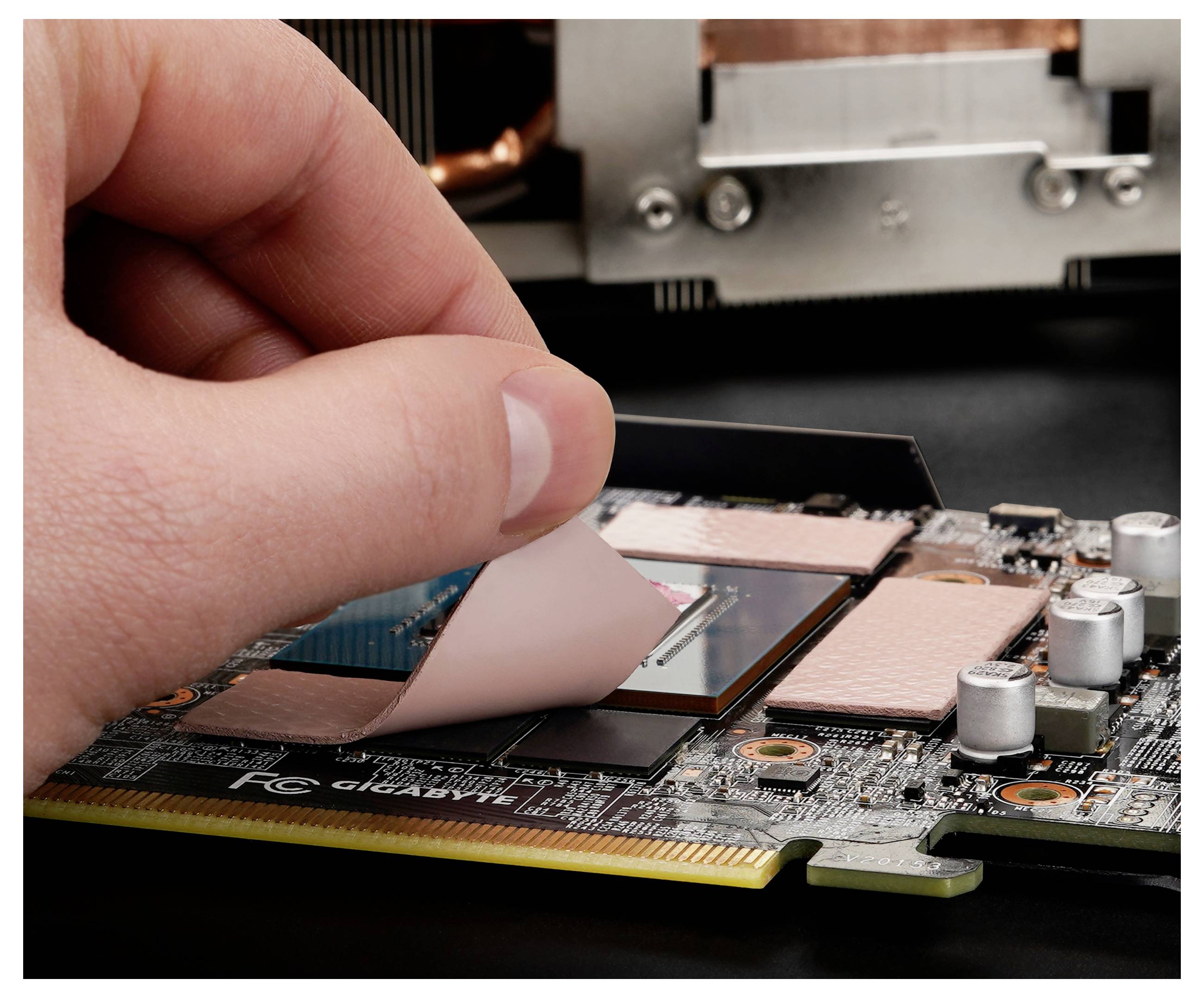 Eine Hand entfernt eine Schutzfolie von einem Computerchip auf einer Grafikkarte und unterstreicht damit die Bereitschaft zur Installation oder Wartung.