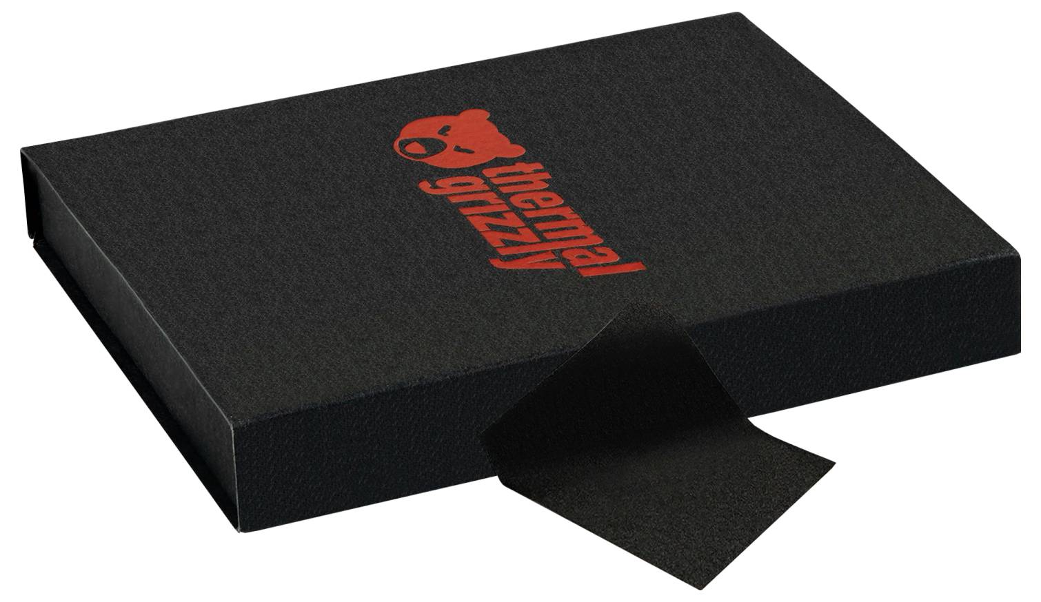 Eine schwarze rechteckige Schachtel mit dem roten 'Thermal Grizzly' Logo und einer Bärgrafik auf dem Deckel. Ein Stoffetikett ist an einer Kante sichtbar.