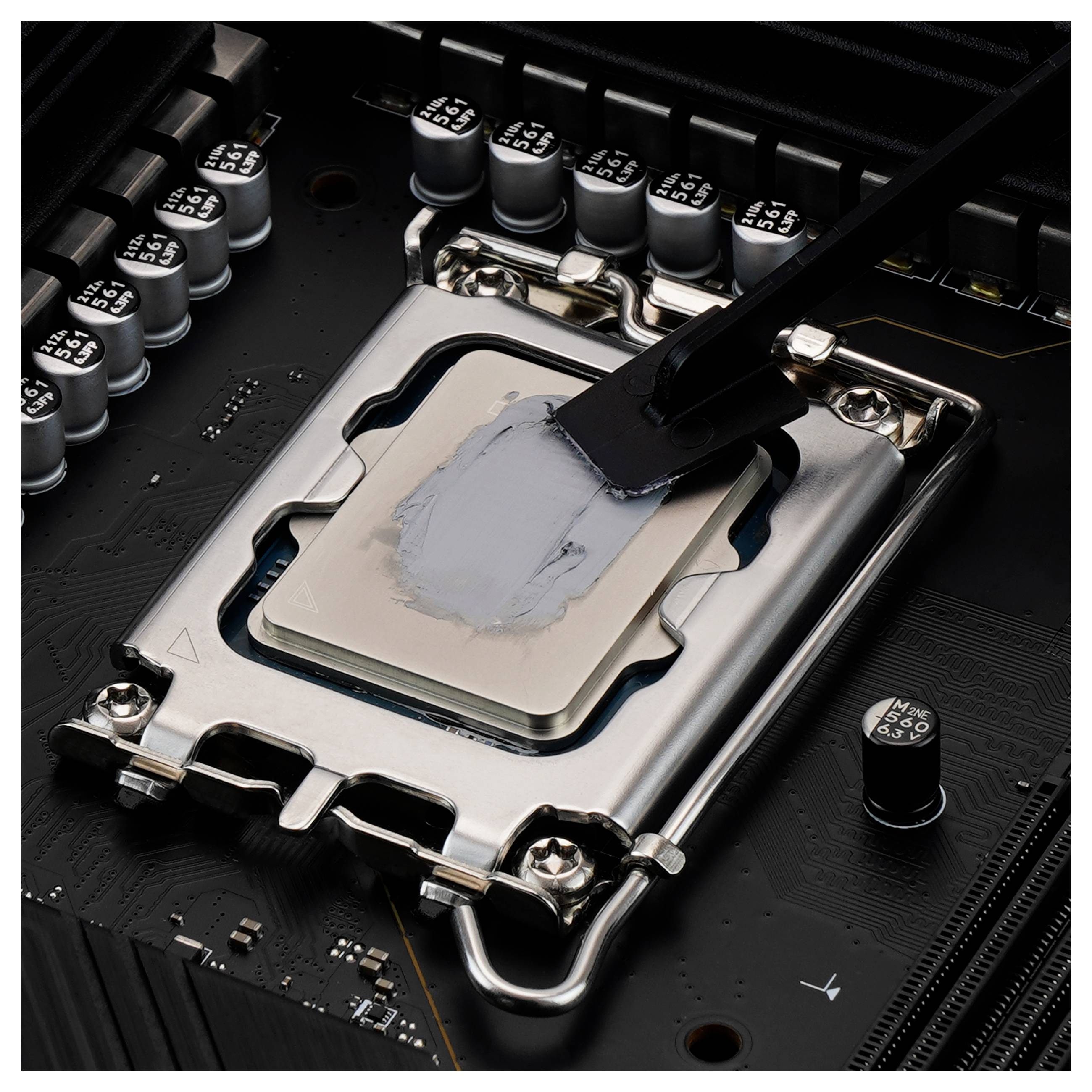 Eine Nahaufnahme eines Computerprozessors, der auf eine Hauptplatine installiert wird. Wärmeleitpaste ist teilweise auf der Oberfläche des Prozessors aufgetragen.