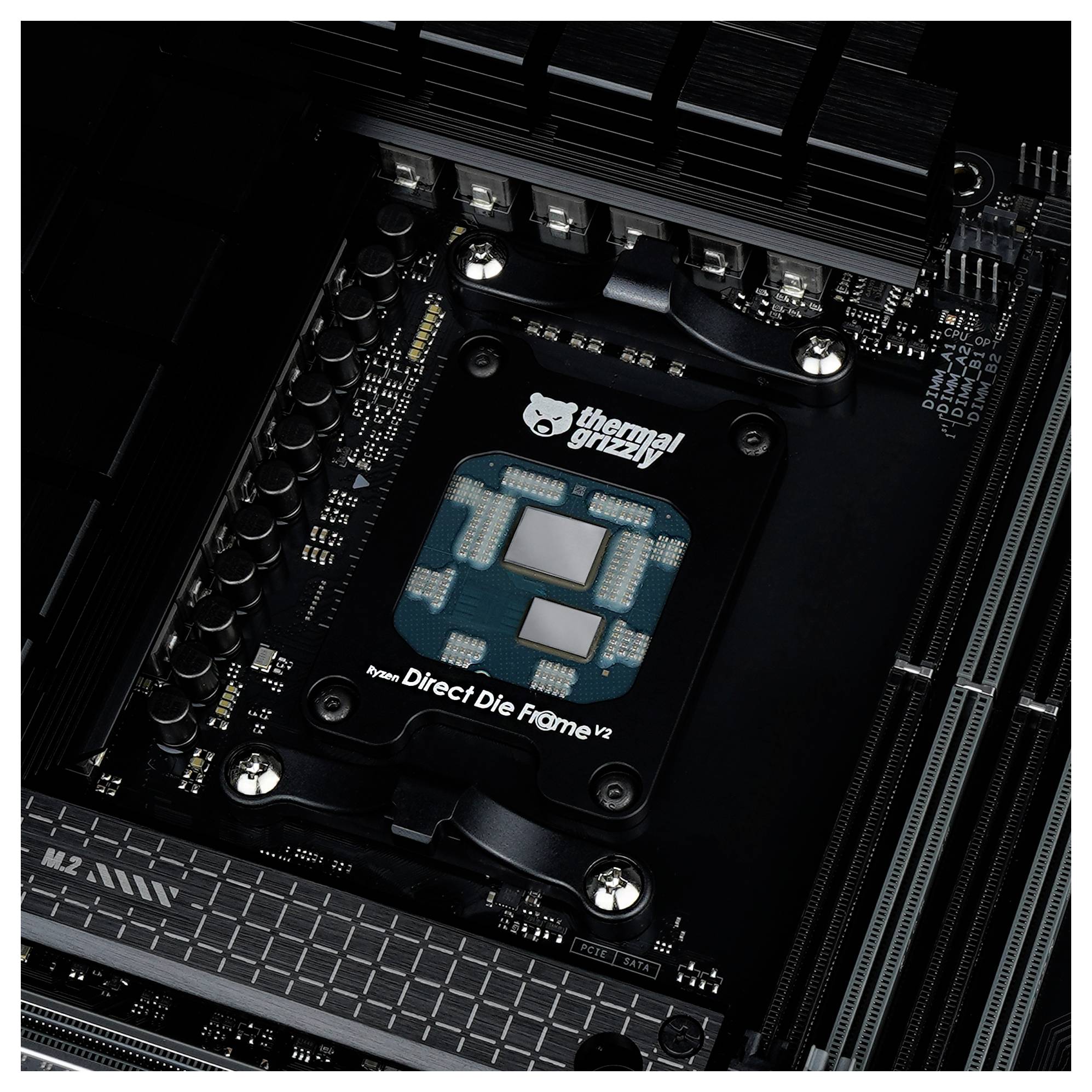Eine Computermotherboard mit einem Thermal Grizzly Direct Die Frame V2, umgeben von Kondensatoren und Kühlkörpern.
