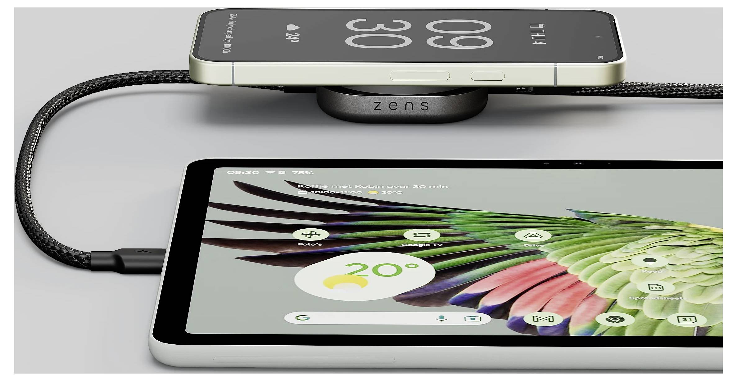 Ein Smartphone und ein Tablet laden drahtlos auf einem Ladegerät. Der Tablet-Bildschirm zeigt ein buntes Vogeldesign und eine Wetter-App, die 20°C anzeigt.