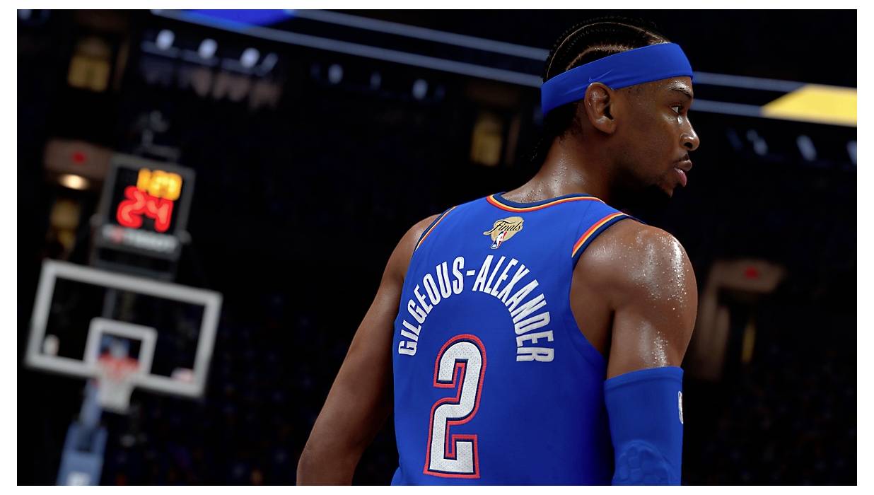 Ein Basketballspieler in einem blauen Trikot mit dem Namen 'Gilgeous-Alexander' und der Nummer '2', die sichtbar sind. Eine Shotclock zeigt '24'.