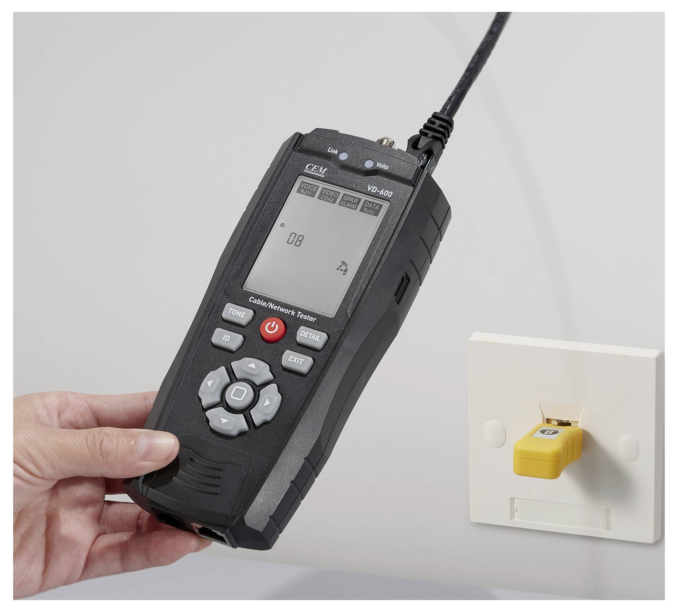 Hand hält ein digitales Kabelnetzwerk-Testgerät, das mit einer Wandsteckdose verbunden ist, zeigt ein numerisches Ergebnis auf dem Bildschirm an und deutet auf Testaktivität hin.