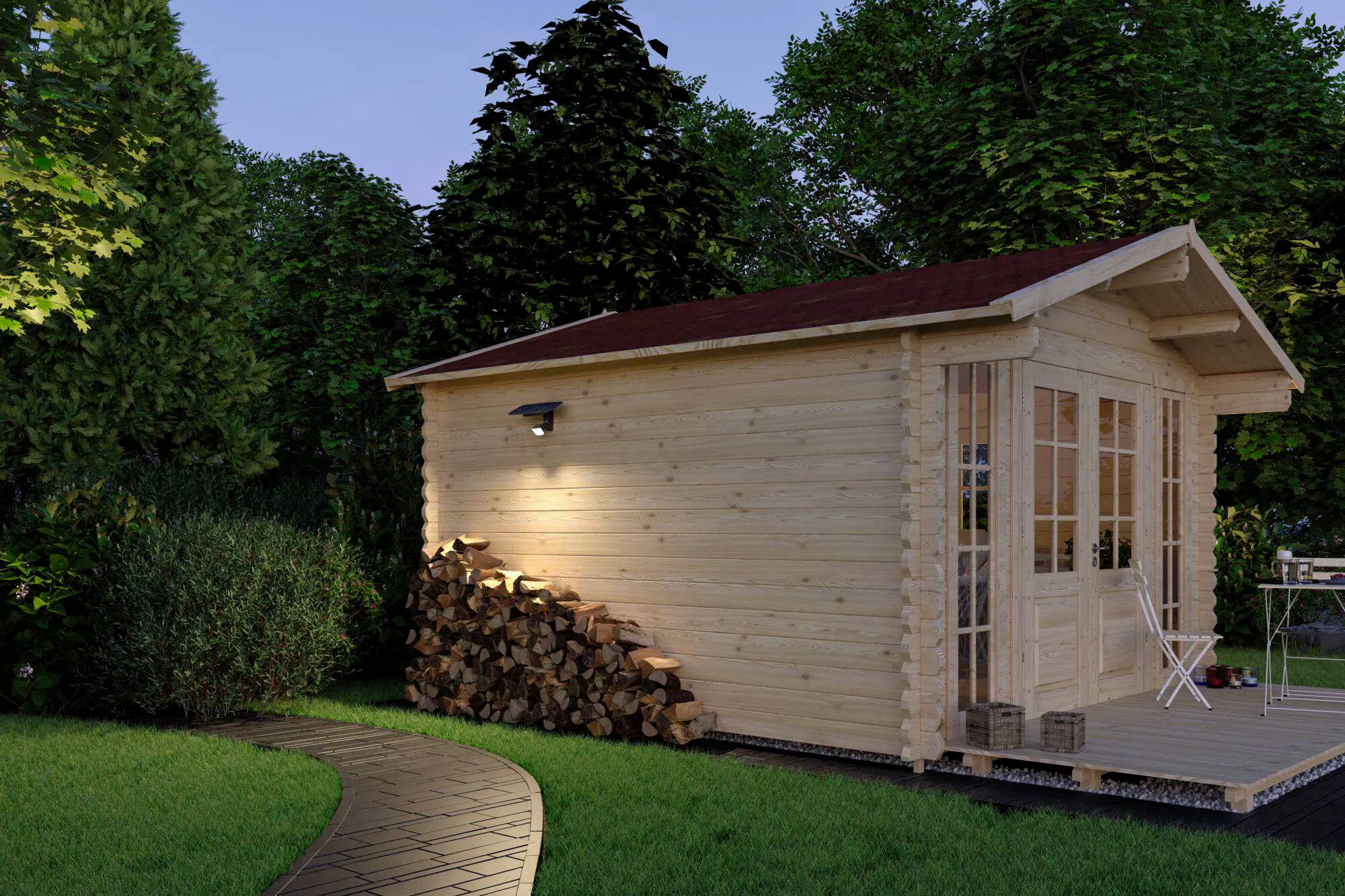 Holzhütte mit rotem Dach, umgeben von Grün und von einer Außenbeleuchtung beleuchtet. Brennholz ist an der Wand gestapelt; ein Weg führt zur Tür.