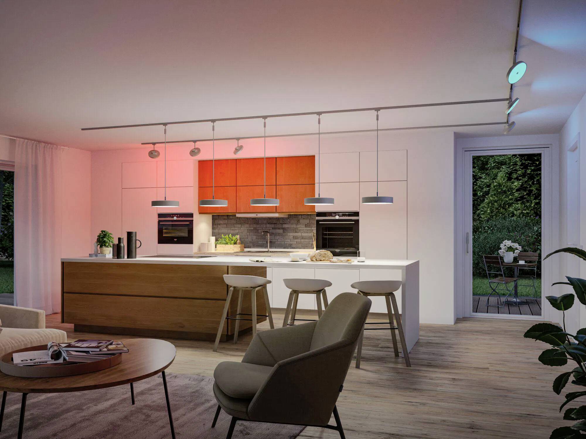 Moderne Küche mit einer Kochinsel, Barhockern und hängenden Leuchten. Schiebetür öffnet sich zum Garten. Warmes Ambientlicht schafft eine gemütliche Atmosphäre.